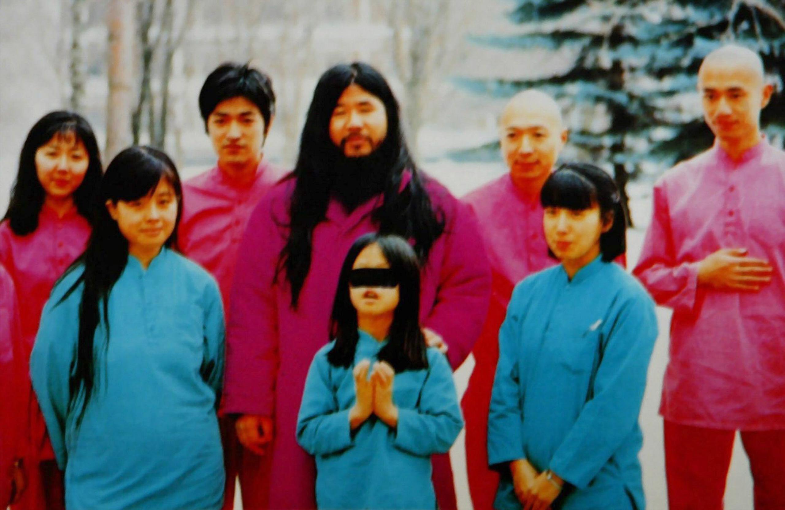 Una copia sin fecha de una foto perteneciente al miembro de culto de Aum que muestra al líder de la secta Shoko Asahara con su esposa Tomoko -en azul a la izquierda- y su hija Archery -en azul al centro- junto con un grupo interno de discípulos. (EPA / HO / EFE)