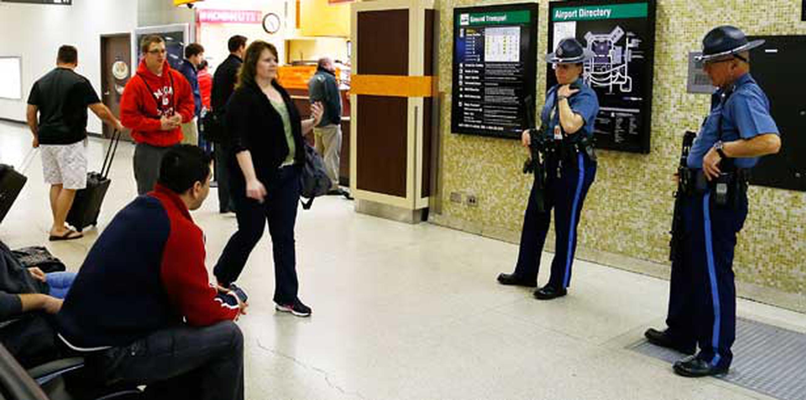 Policías prestan vigilancia en el área de reclamar el equipaje en el aeropuerto de Boston.  (Jared Wickerham/Getty Images/AFP)