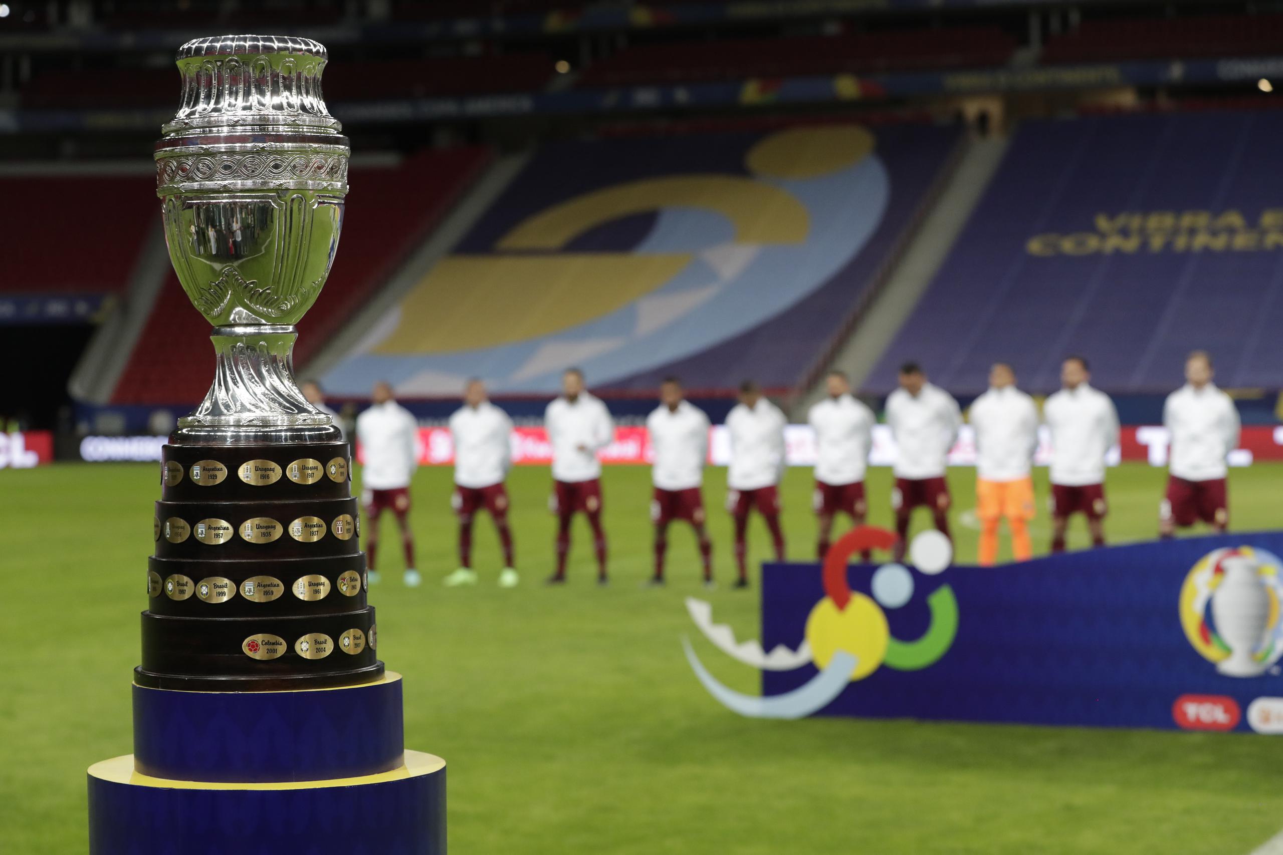 La foto del domingo 13 de junio de 2021 muestra el trofeo de la Copa América, delante de los jugadores de Venezuela, durante la interpretación de los himnos nacionales, previa al partido inaugural entre ese equipo y Brasil, en el Estadio Nacional de Brasilia.