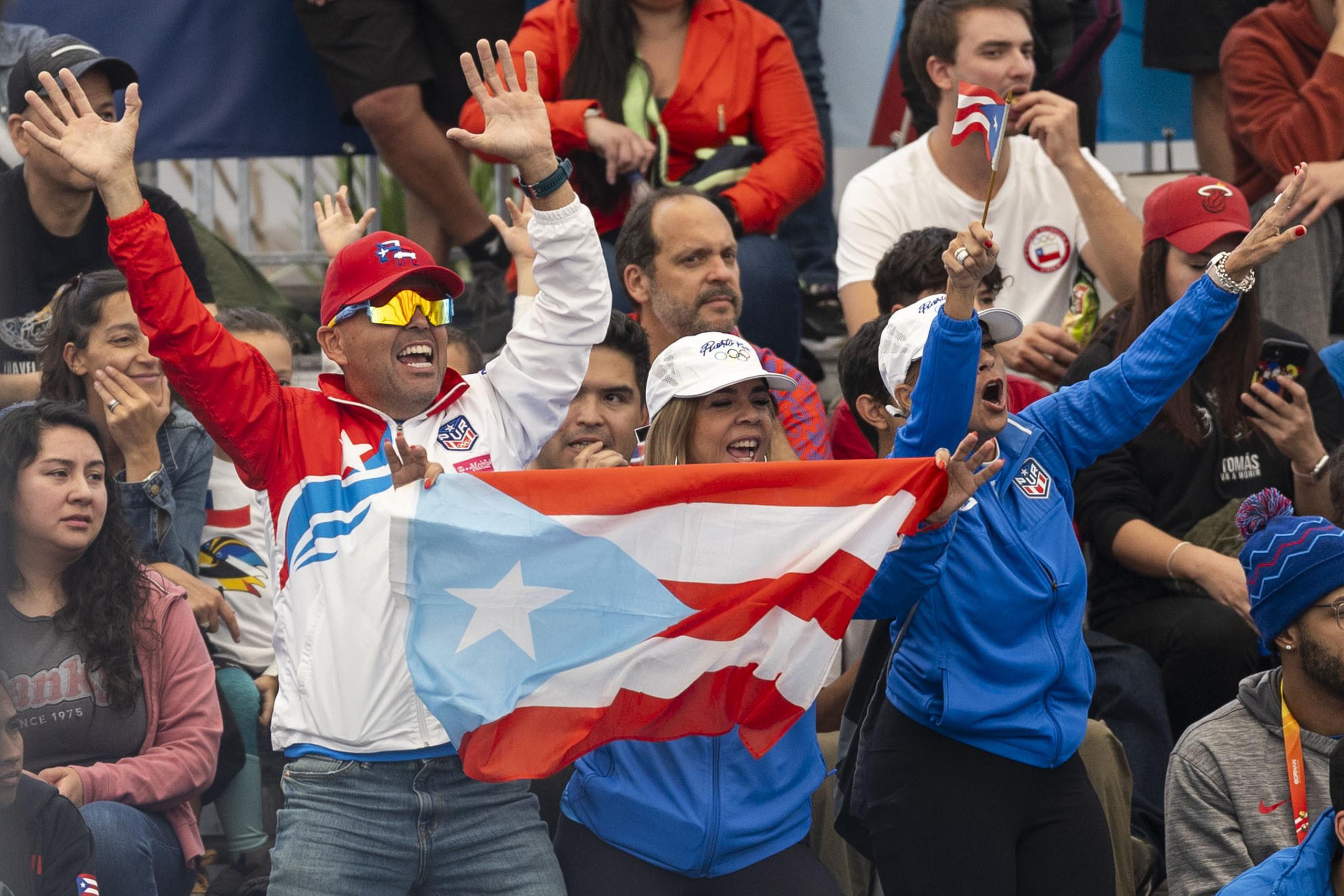 Un grupo de puertorriqueños celebra una de las victorias de los boricuas esta tarde en Santiago.
