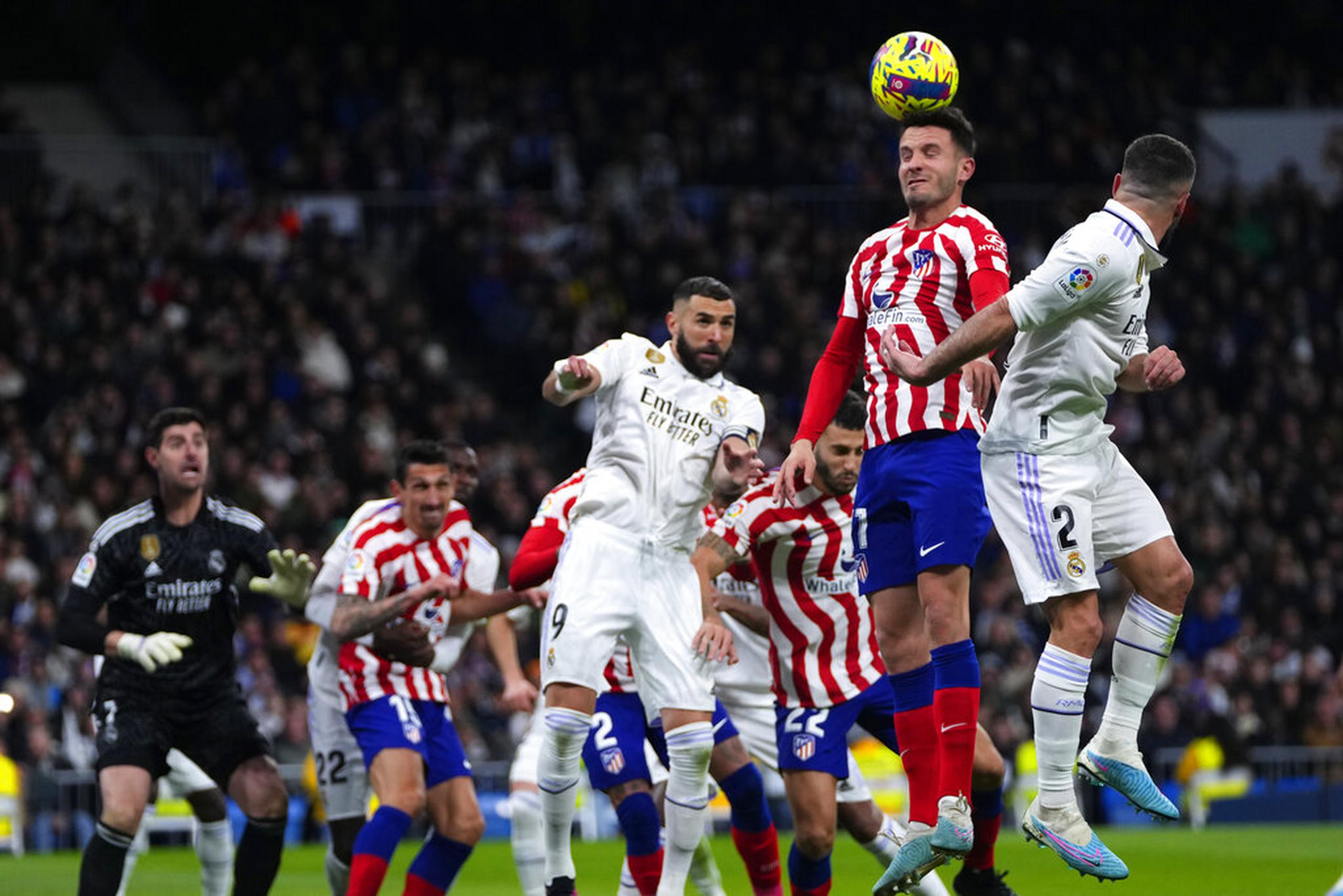 Saul, del Atlético de Madrid, cabecea el balón frente a Dani Carvajal, del Real Madrid, en el derbi de la liga española en el Estadio Santiago Bernabéu.