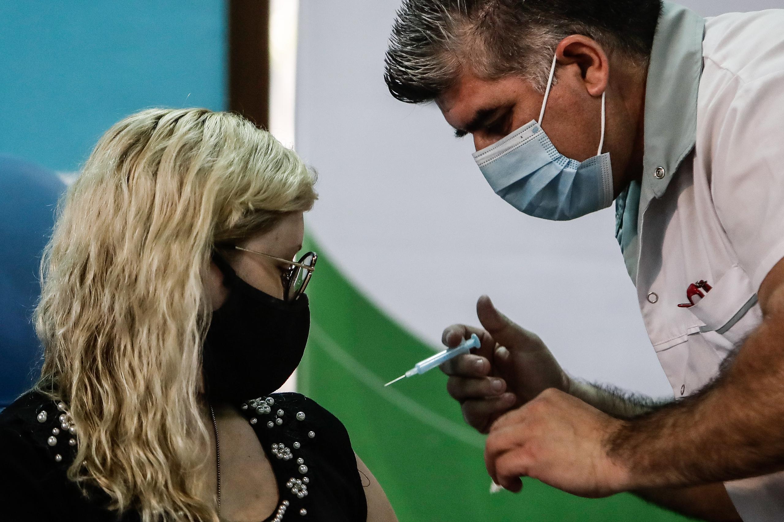 Una mujer es vacunada hoy contra el covid-19 en el Hospital Fiorito, en Avellaneda (Argentina).