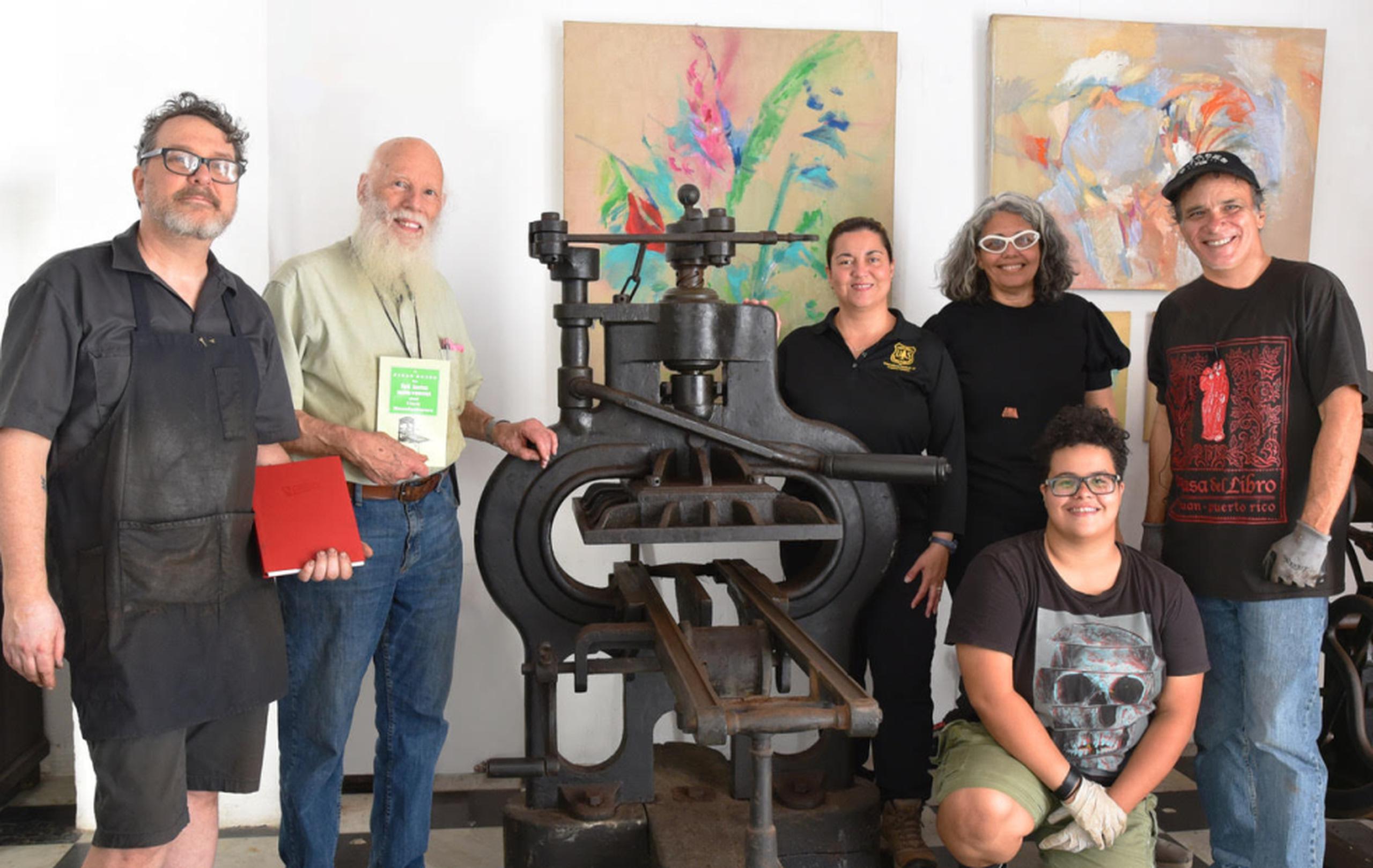 Desde la izquierda, Paul Moxon y Robert Oldham, junto a personal; y estudiantes que laboran en la Casa del Libro.