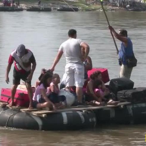Familias desesperadas arriesgan sus vidas cruzando un río sobre balsas