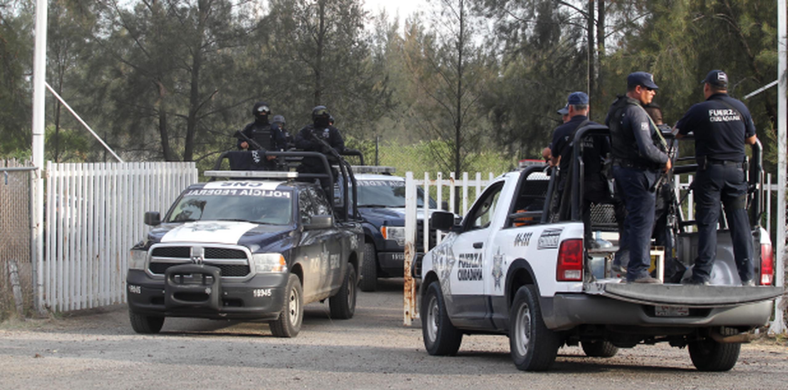 Policías y soldados mexicanos vigilan la entrada al rancho donde se produjo el enfrentamiento con miembros del cartel Jalisco Nueva Generación. (AP)