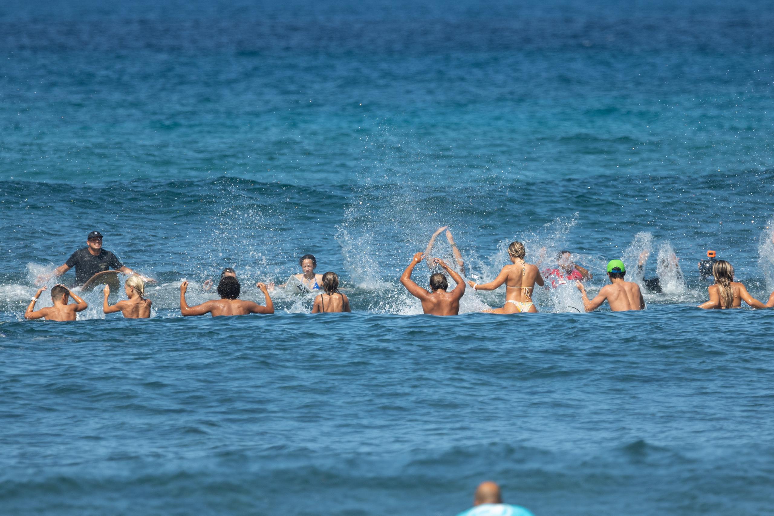 Como parte de la tercera parada, los surfers hacen el tradicional círculo para honrar a uno de los suyos, Juan García González, conocido en el ambito del surfing como 'Kiko Rabia' quien murio recientemente en playa Los Tubos en Vega Baja.