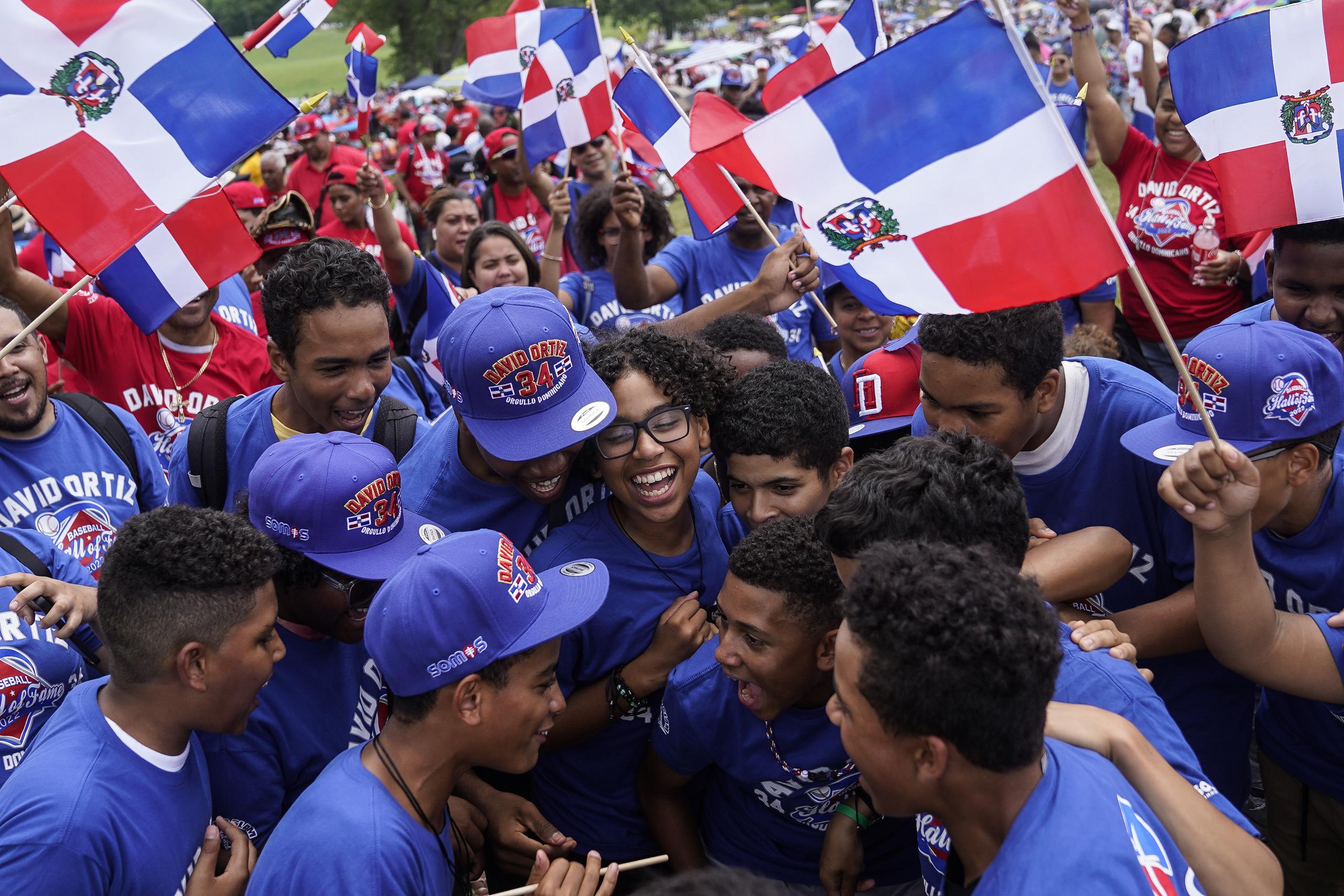 Fans de David Ortiz, nuevo miembro del Salón de la Fama del béisbol, celebran durante la ceremonia de exaltación, el domingo 24 de julio de 2022 en Cooperstown, Nueva York (AP Foto/John Minchillo)