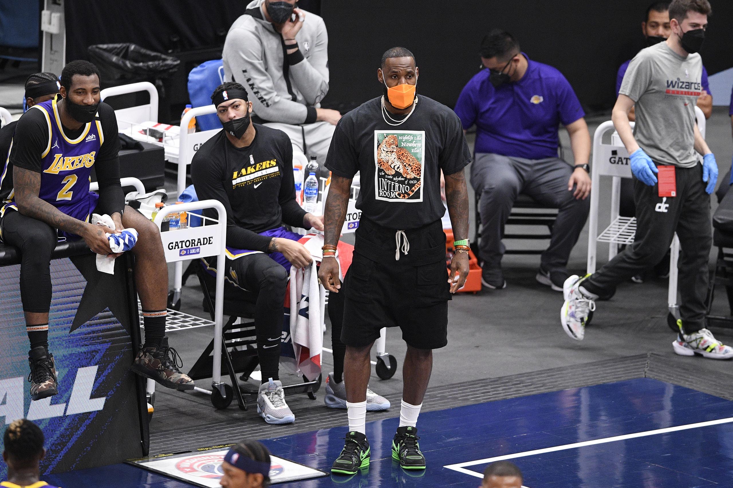 LeBron James, con una mascarilla naranja, observa el partido de los Lakers frente a Washington.
