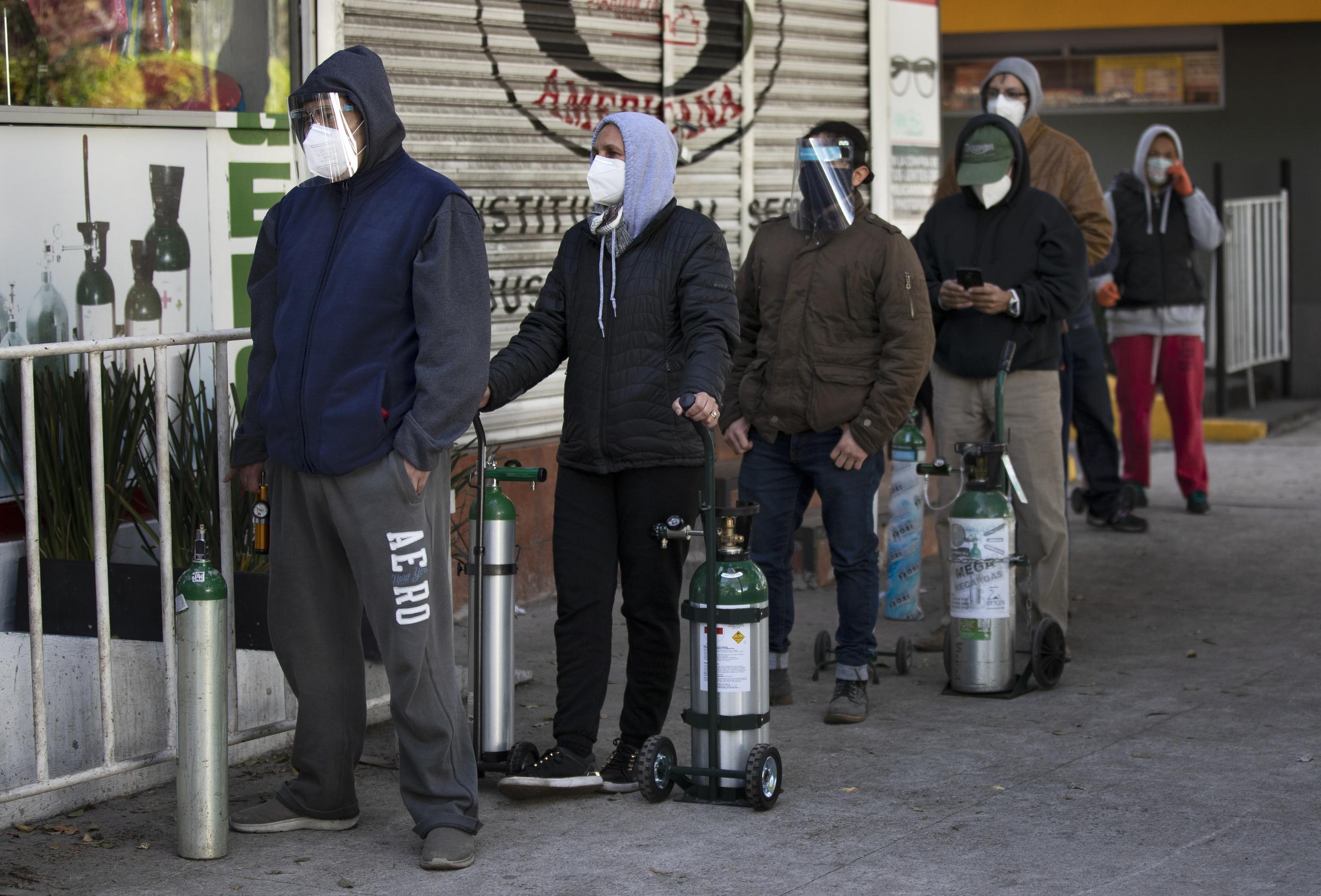 Varias personas hacen fila el 31 de diciembre de 2020 para rellenar tanques de oxígeno requeridos por personas enfermas de coronavirus, en la Ciudad de México.