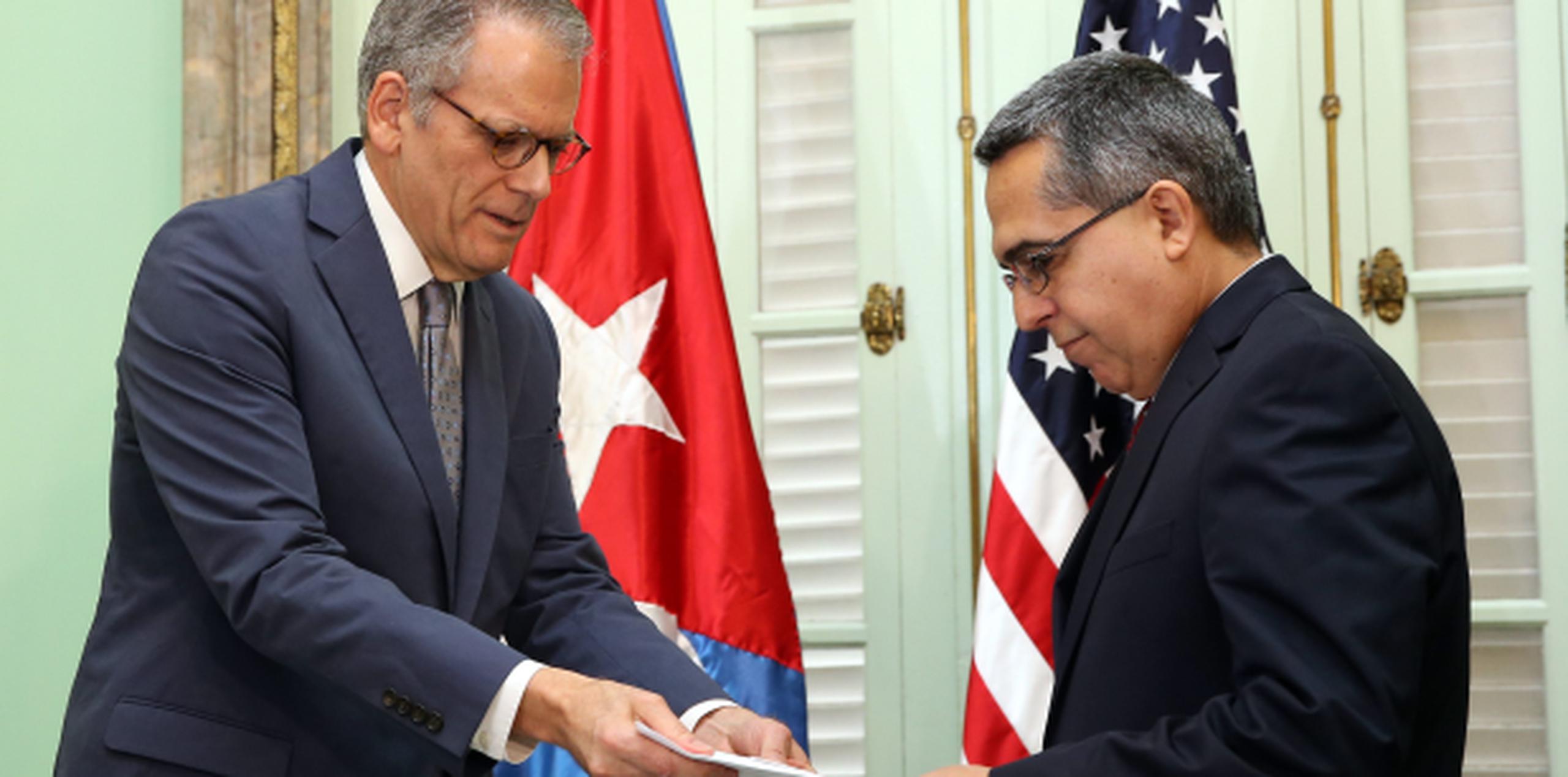 El ministro interino de Relaciones Exteriores de Cuba, Marcelino Medin entrega documentos al jefe de la Sección de Intereses de Estados Unidos en La Habana, Jeffrey DeLaurentis. (EFE)
