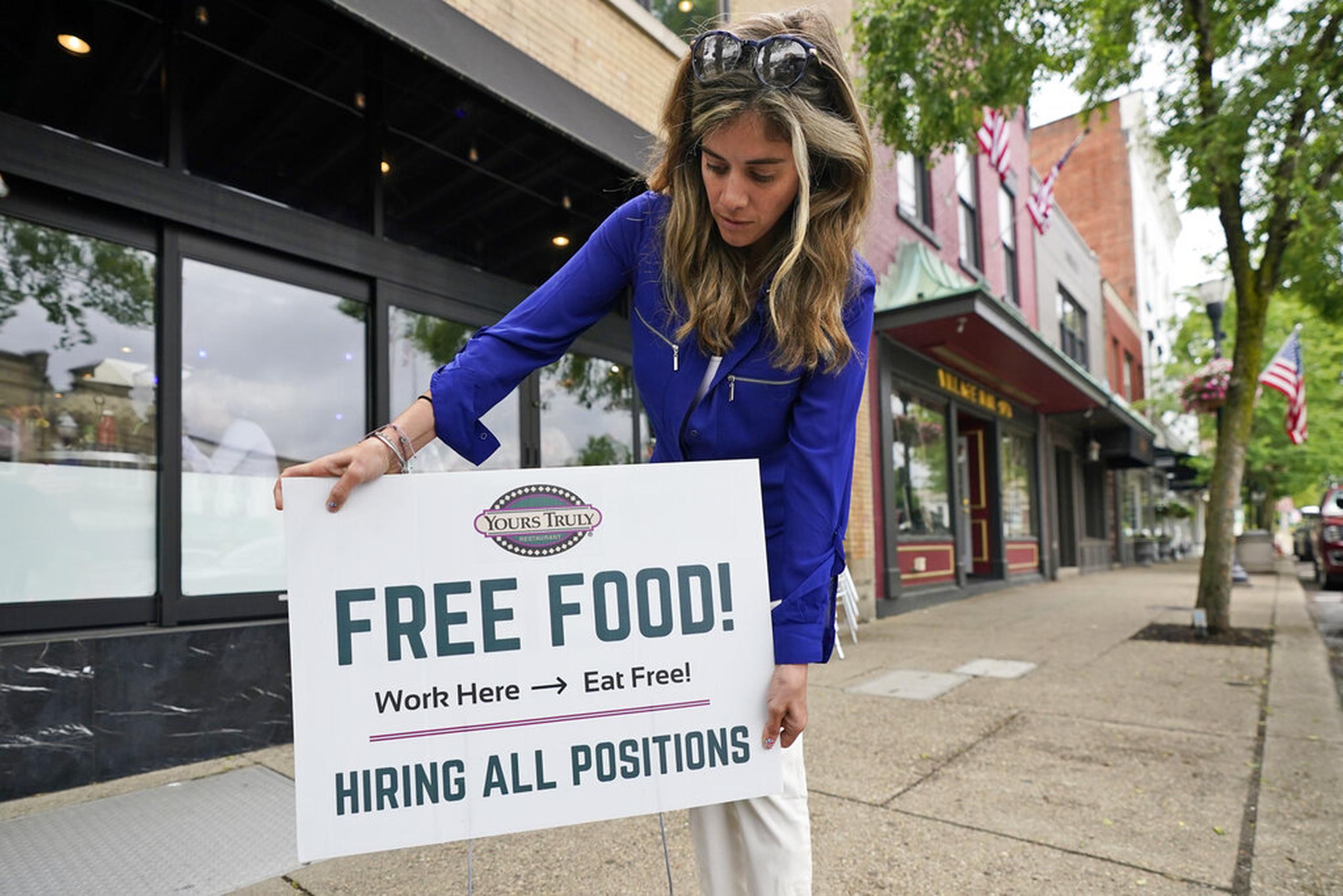 Coleen Piteo, director de mercadeo del restaurante Yours Truly, pone un cartel de contratación que ofrece comida a empleados, en Chagrin Falls, Ohio.