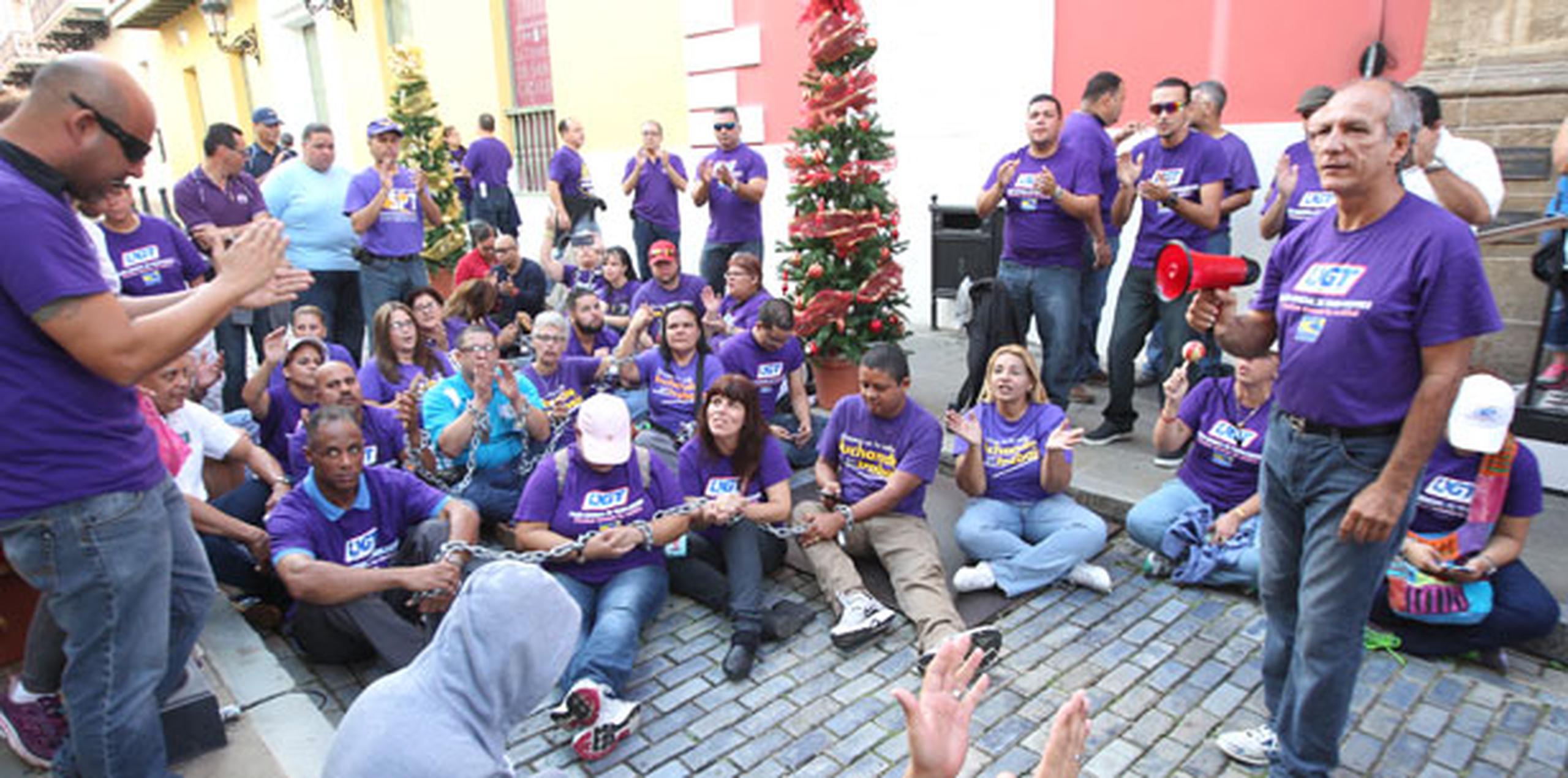 Los unionados de la UGT están sentados sobre los adoquines, frente al Palacio Rojo, para reclamarle al gobernador Alejandro García Padilla que se emita el desembolso de $120 millones por concepto del bono navideño. (alex.figueroa@gfrmedia.com)
