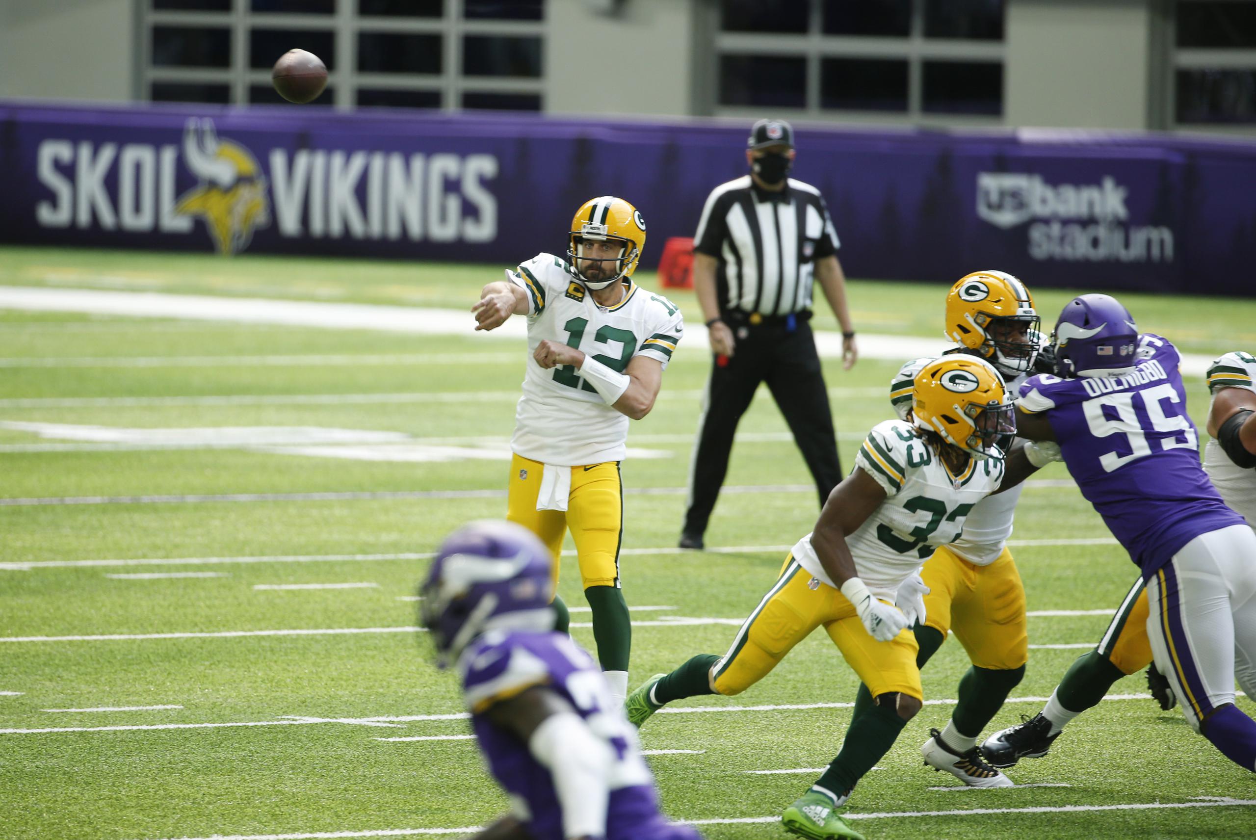 Aaron Rodgers (12) de los, Packers de Green Bay, realiza un pase durante la primera mitad del partido del domingo ante Minnesota.