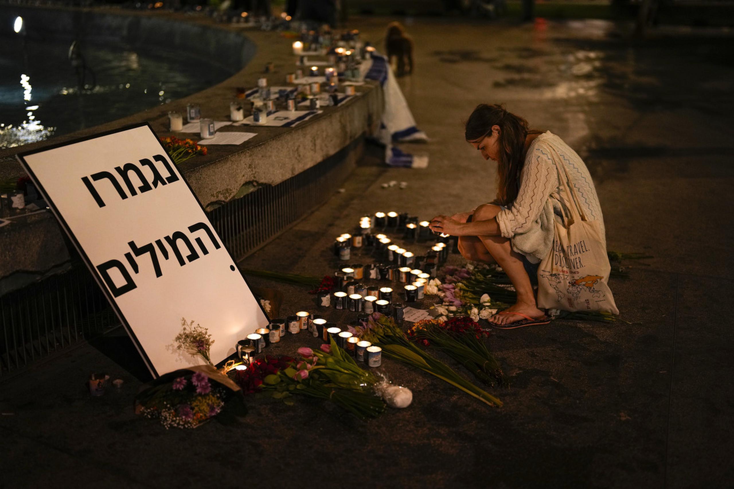 Una mujer enciende una vela en honor a las víctimas del ataque de Hamas durante una vigilia en el centro de Tel Aviv.