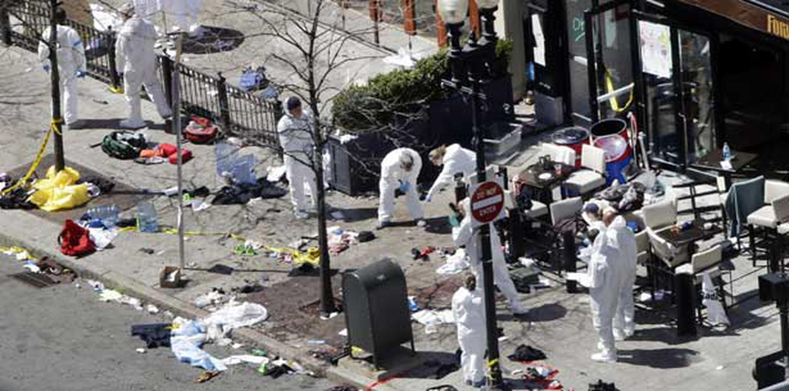 Investigadores examinan el área donde estalló una de las bombas en Boston. (AP /Elise Amendola)


