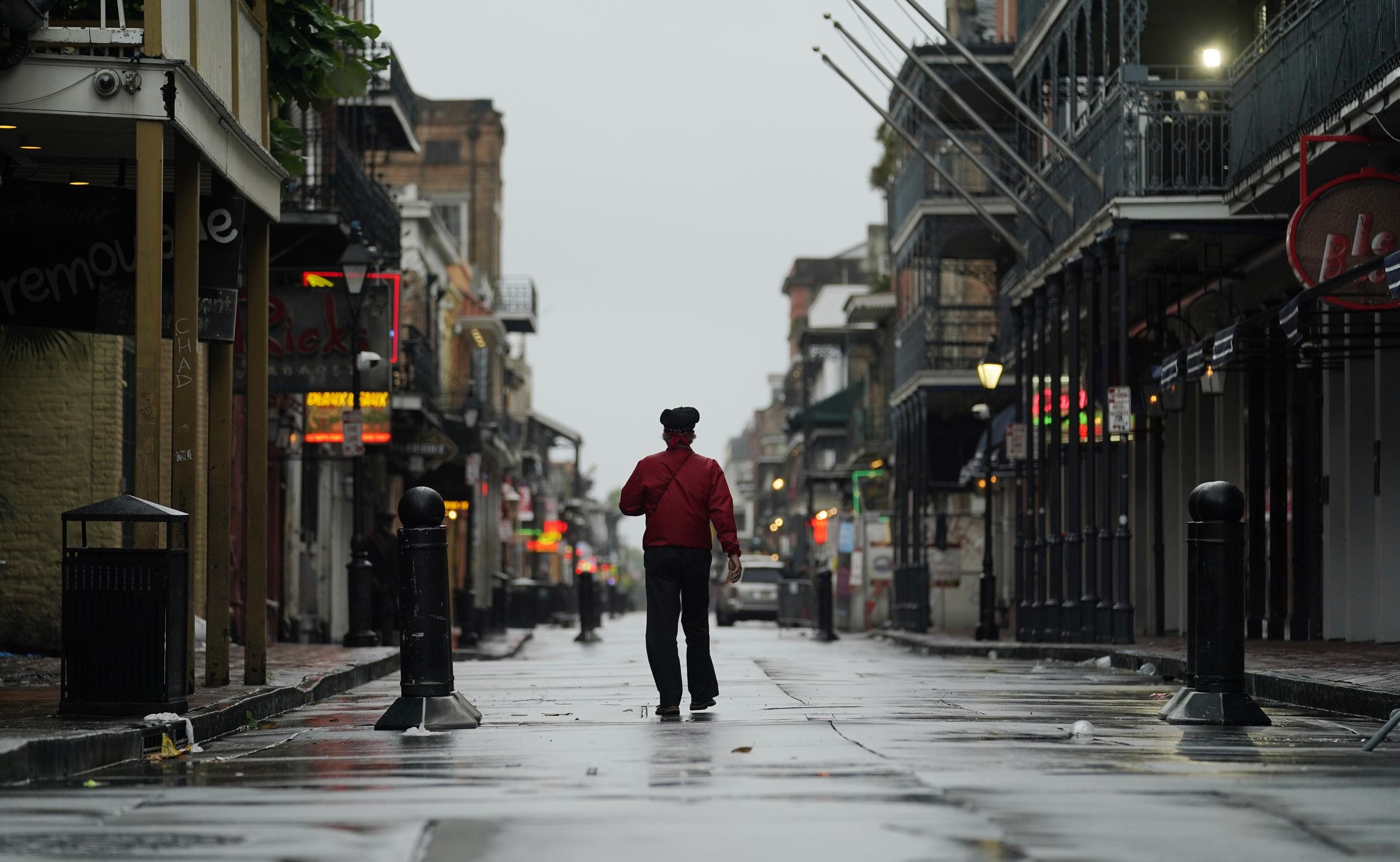 Un hombre camina sobre la calle Bourbon en el distrito francés antes de la llegada del huracán ida, el domingo 29 de agosto de 2021, en Nueva Orleans. (AP Foto/Eric Gay)