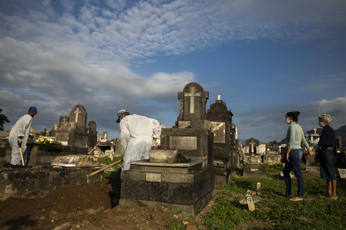 Dos familiares de una víctima del COVID-19 asistían a su entierro el viernes en el cementerio de Inhauma en Río de Janeiro. Se prevé que Brasil alcance el medio millón de muertes por el coronavirus este fin de semana, aunque fuentes médicas estiman que ese número podría estar fácilmente en los 800,000.