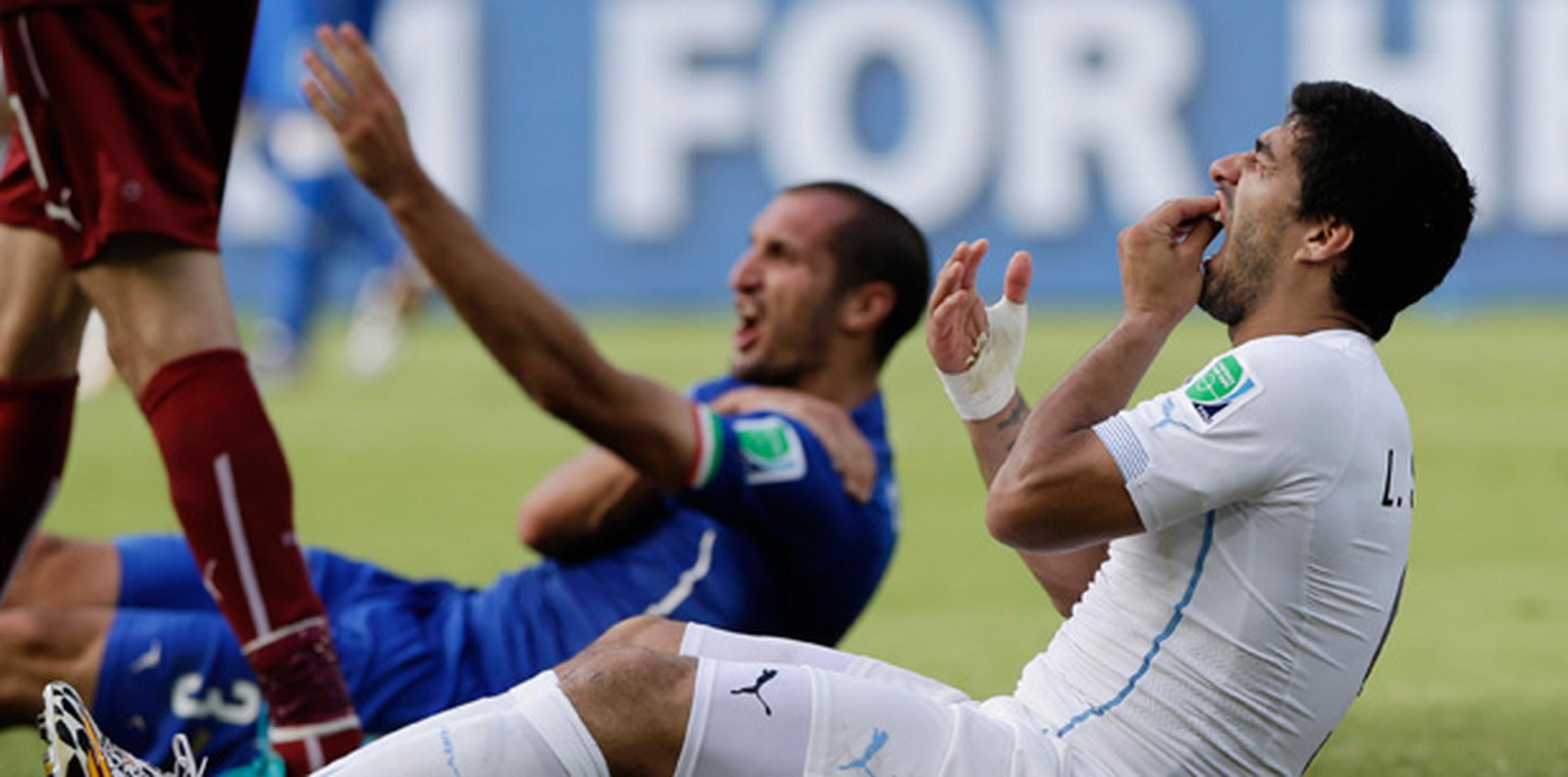 El jugador italiano Giorgio Chiellini le reclama al árbitro que Luis Suárez lo mordió en el hombro. (AP)
