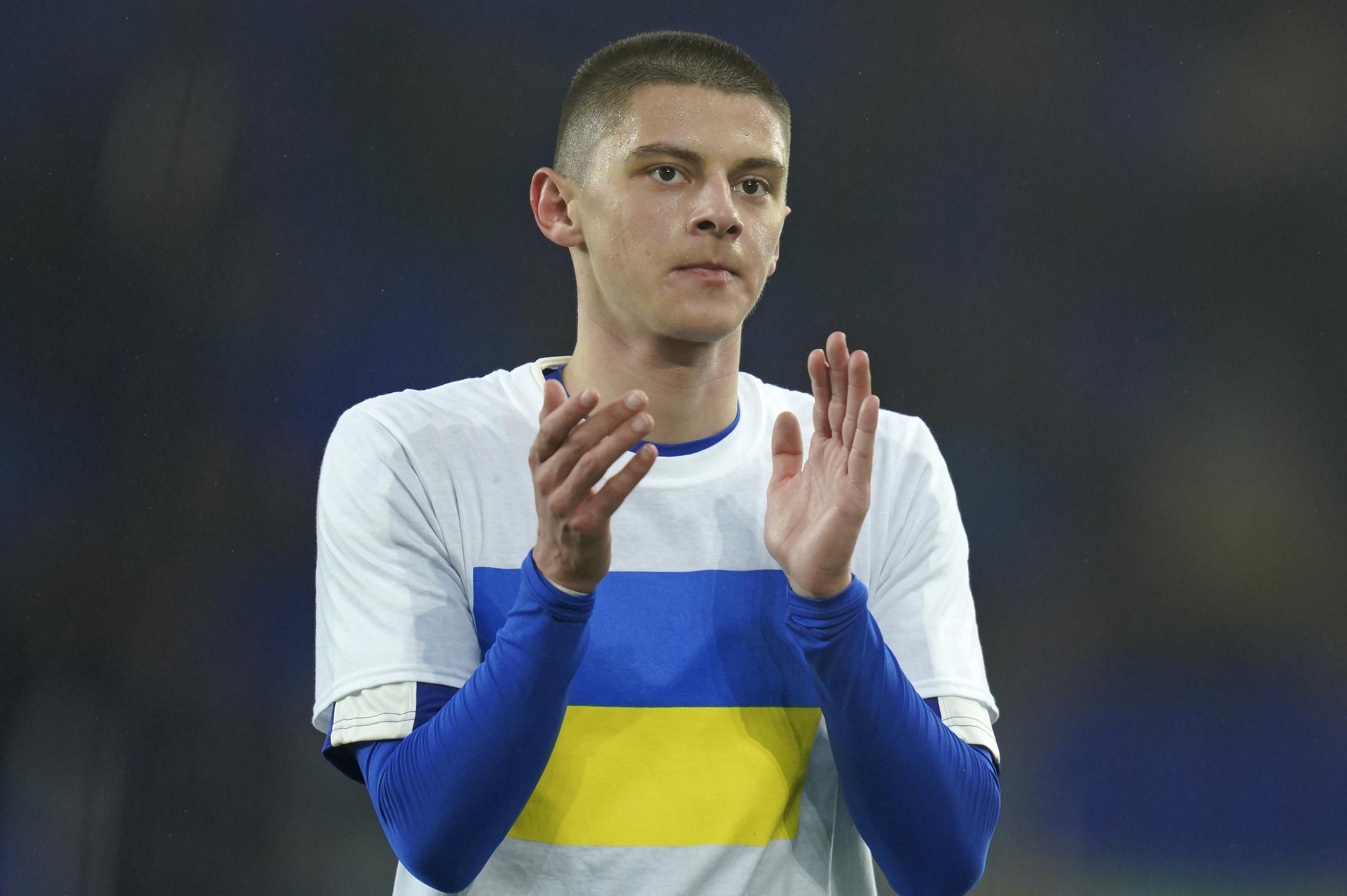 El ucraniano Vitaliy Mykolenko, del Everton, aplaude con una camiseta que muestra la bandera de su país antes de un partido ante el Liverpool en la Premier League.