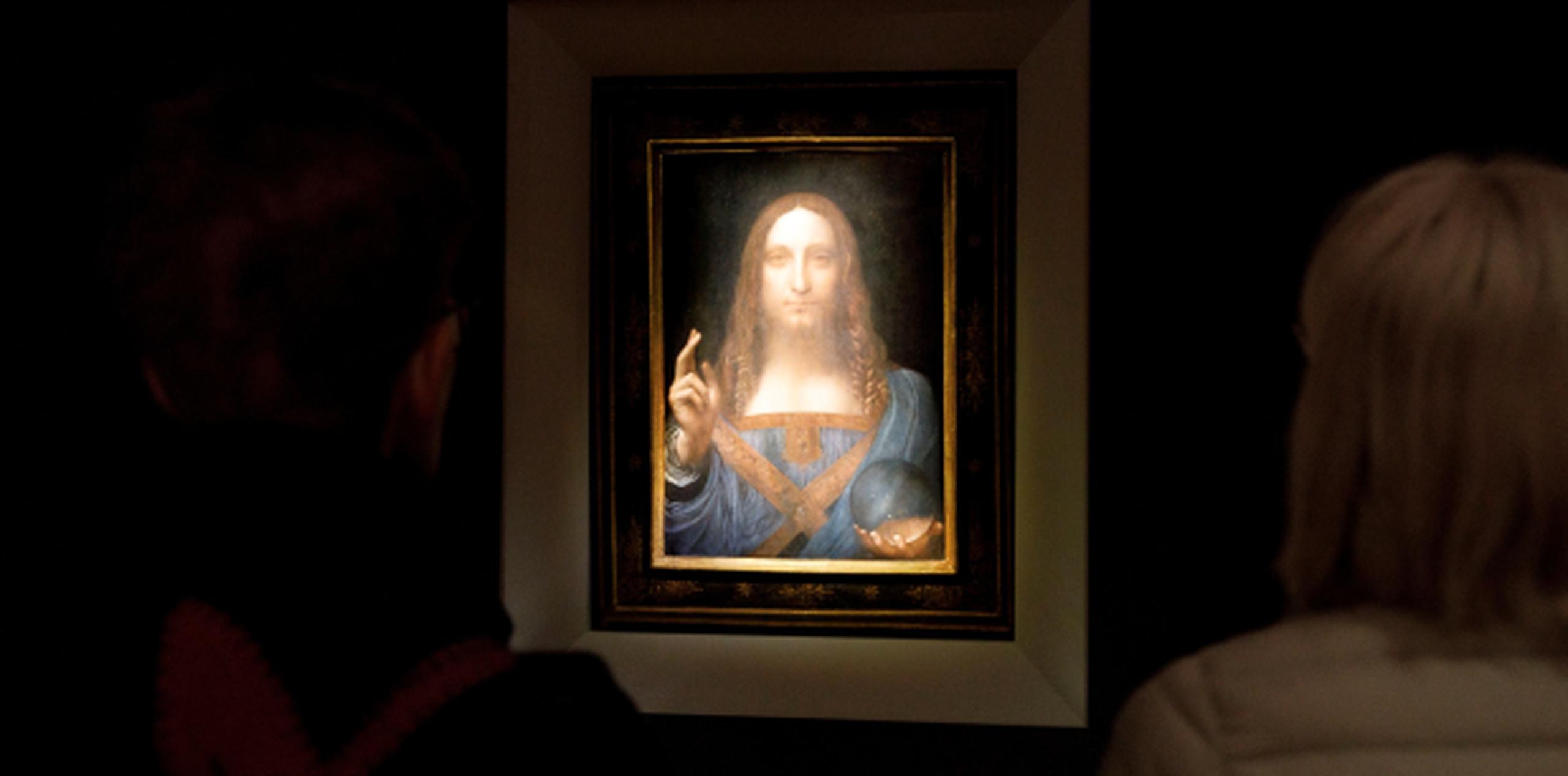 Varias personas observan en Nueva York la obra "Salvator Mundi" del artista Leonardo da Vinci, durante una vista previa pública antes de que la casa Christie's lo subastara. (EFE/ Justin Lane)