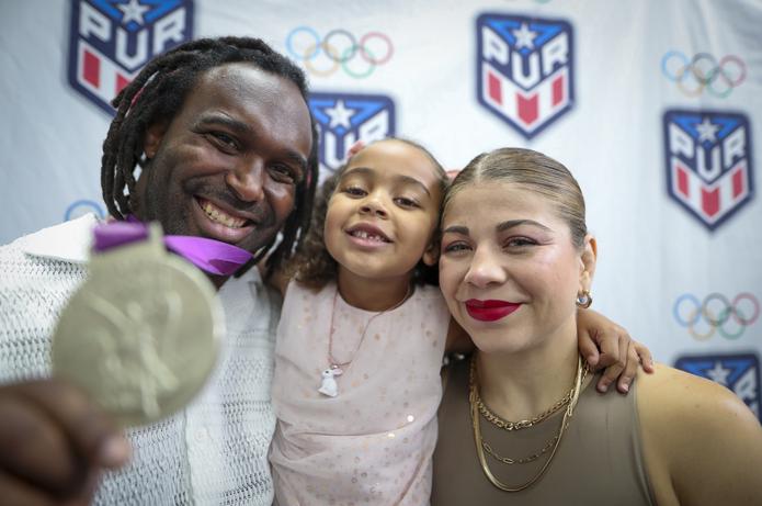 Jaime Espinal nuestra la medalla de plata que ganó en Londres 2012. Le acompañan su hija Joy y su esposa Jane Valencia.
