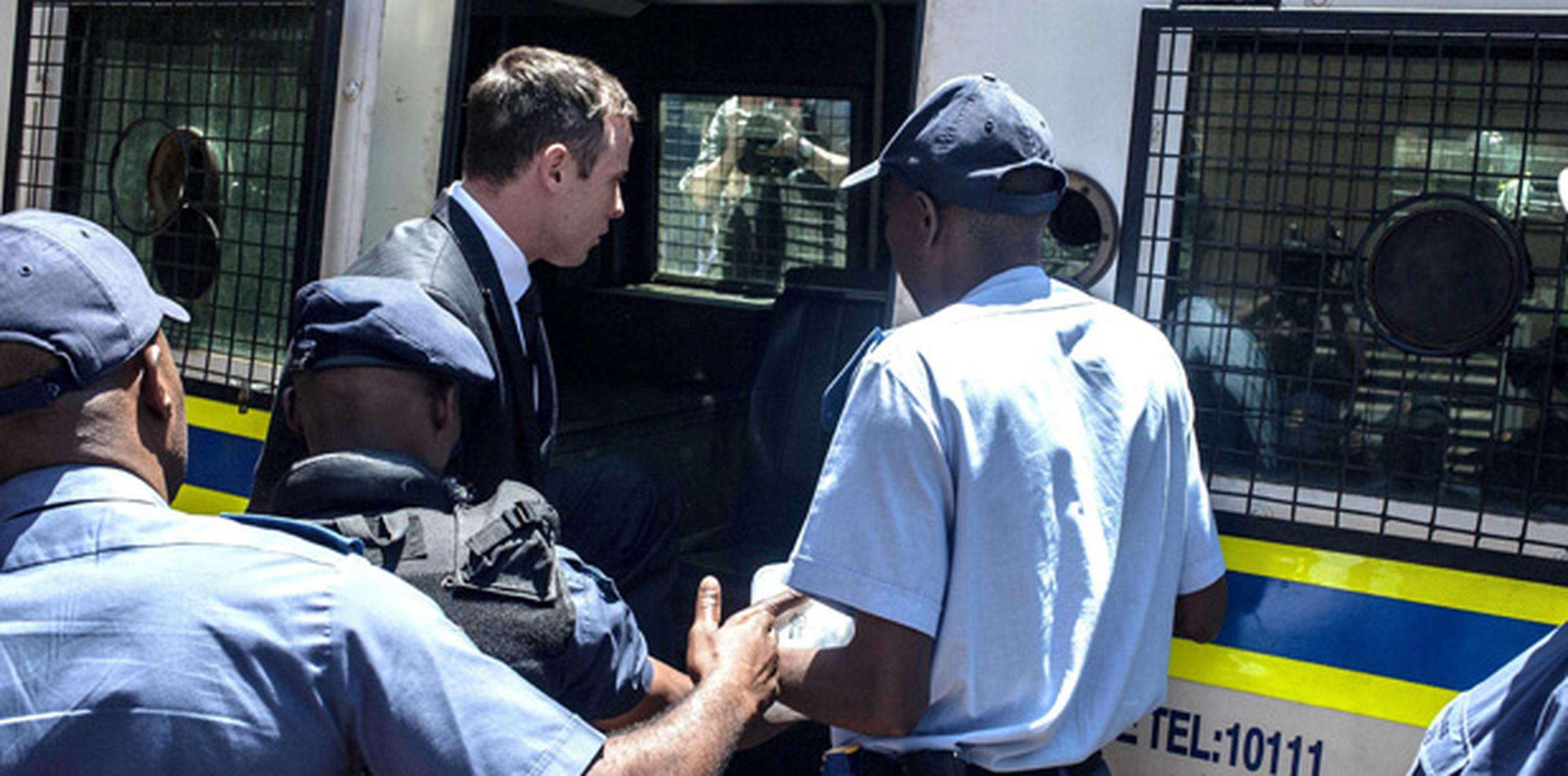 El atleta paralímpico sudafricano Oscar Pistorius entra al furgón policial a su salida del Tribunal Superior de Pretoria. (EFE)