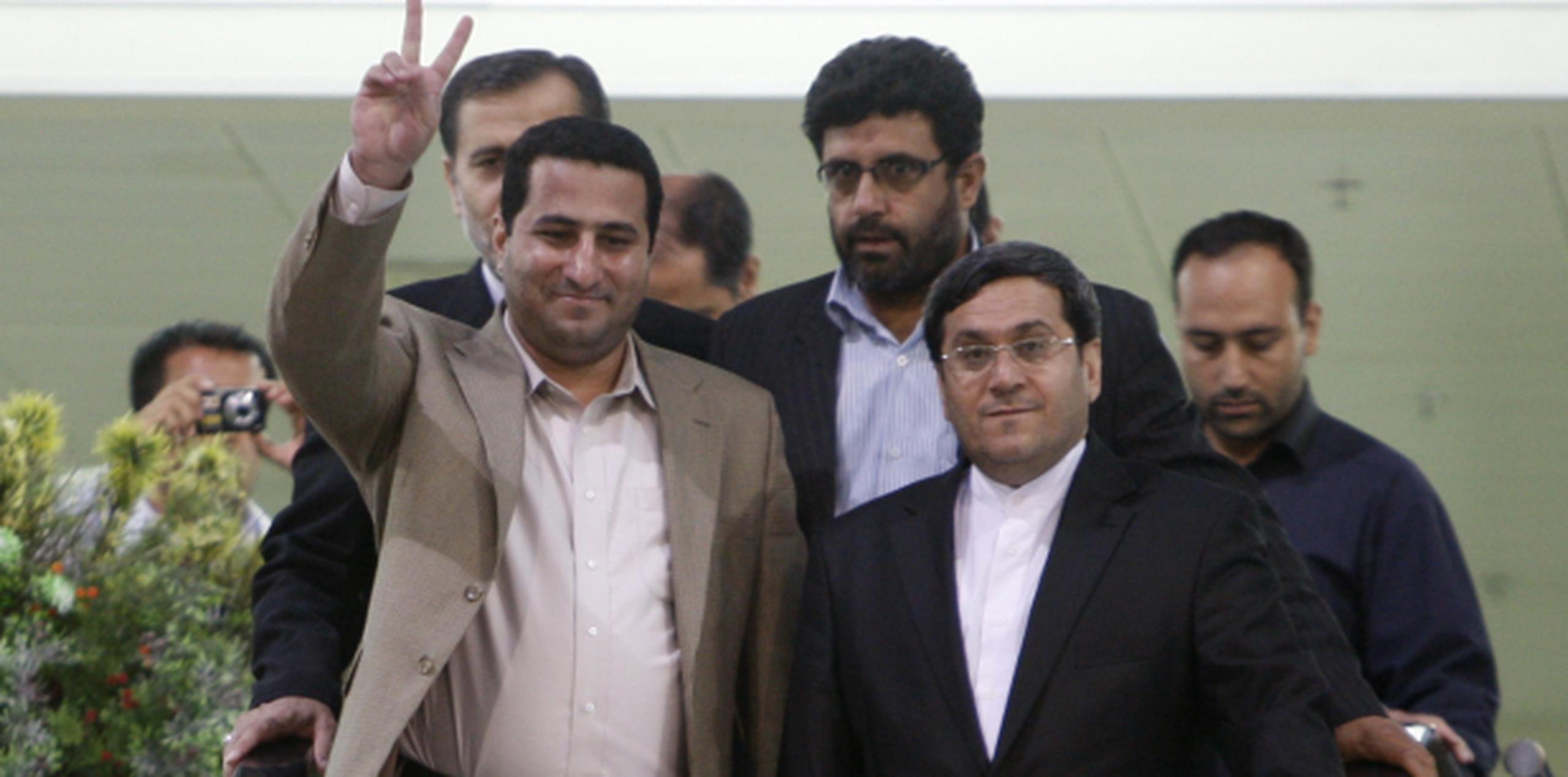 Sonriente y haciendo un gesto de victoria, Shahram Amir regresó a Irán en el 2010, donde fue recibido como un héroe. A la derecha, el canciller iraní en funciones Hassan Qashqavi. (AP)