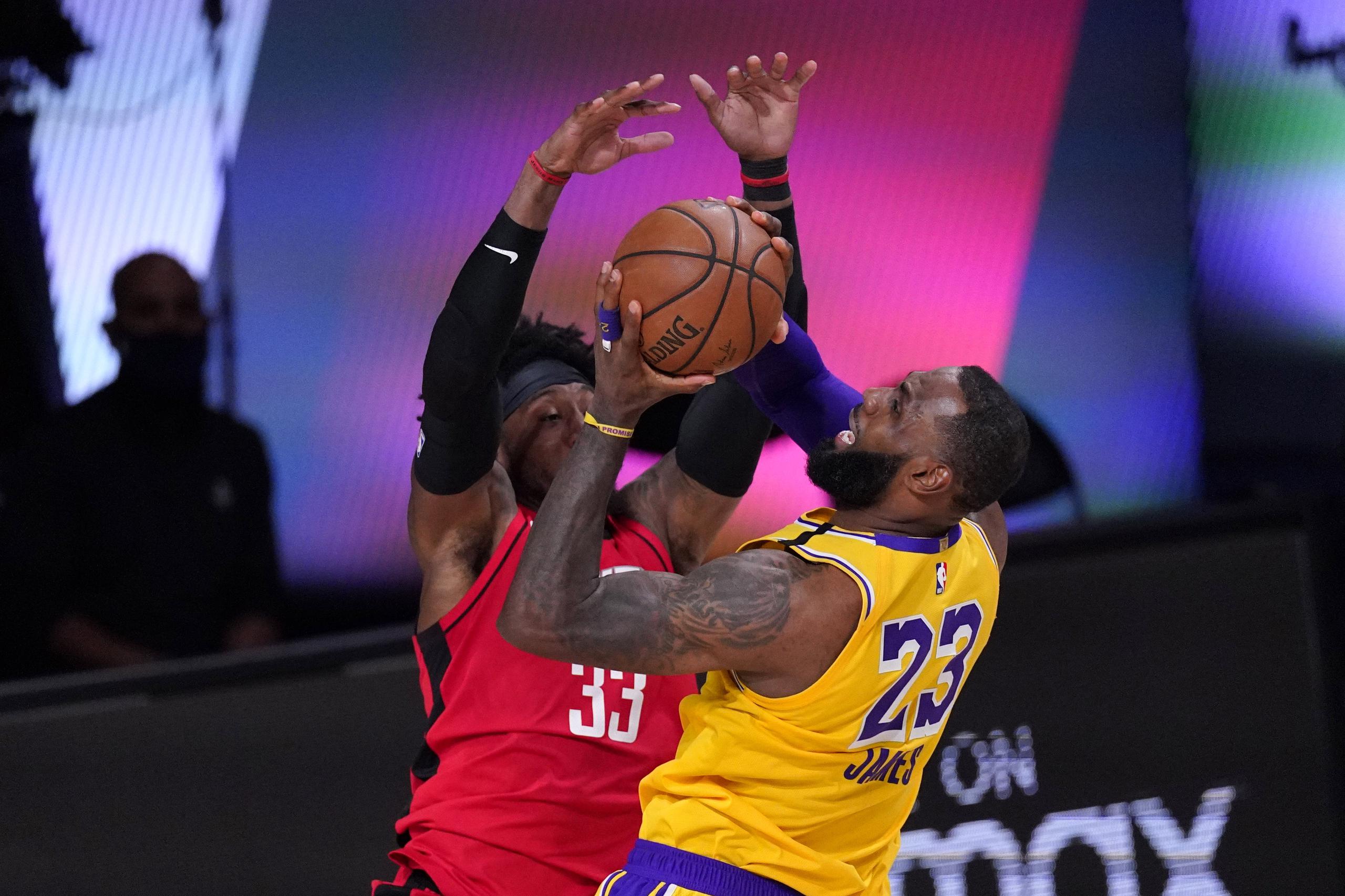 LeBron James, de los Lakers, se dirige hacia el canasto contra la defensa de Robert Covington, de los Rockets, durante el encuentro del jueves.