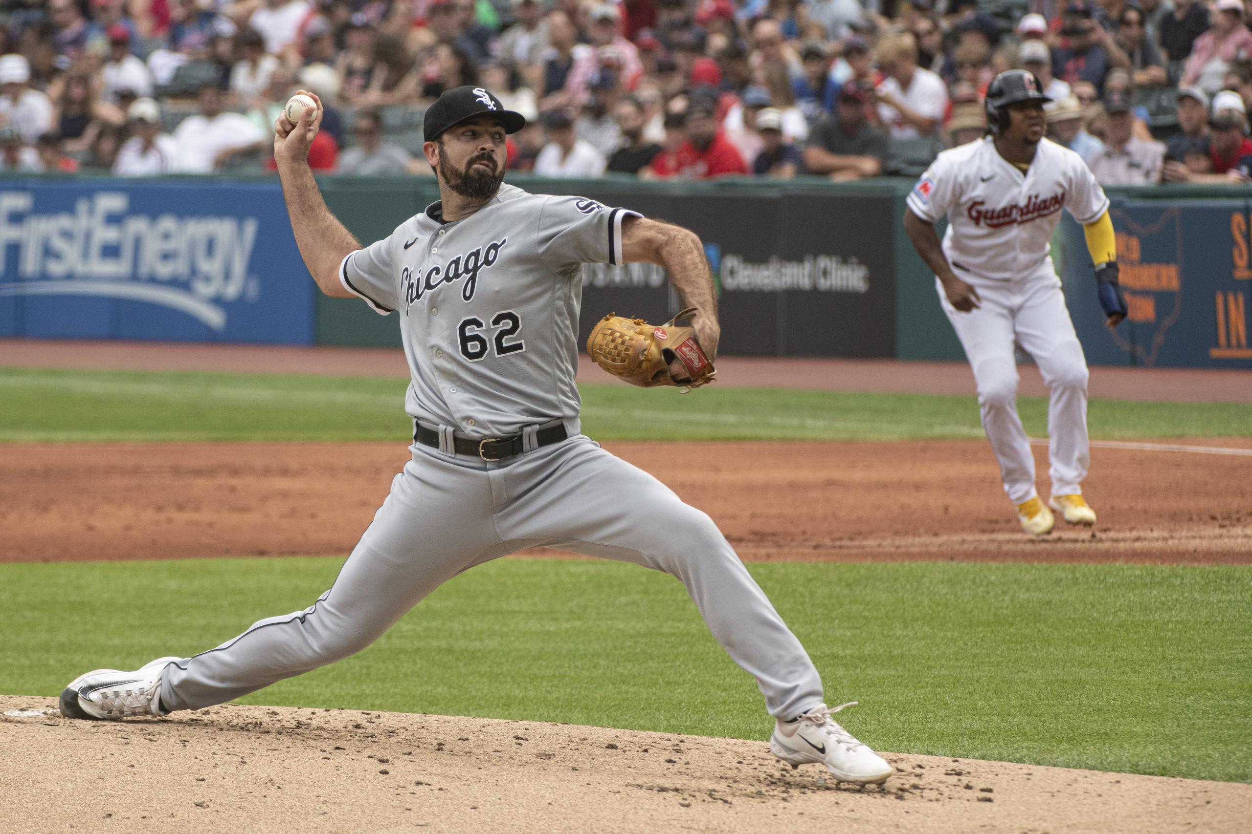 Jesse Scholtens de los White Sox de Chicago lanza mientras José Ramírez de los Guardians de Cleveland aguarda en la primera base.