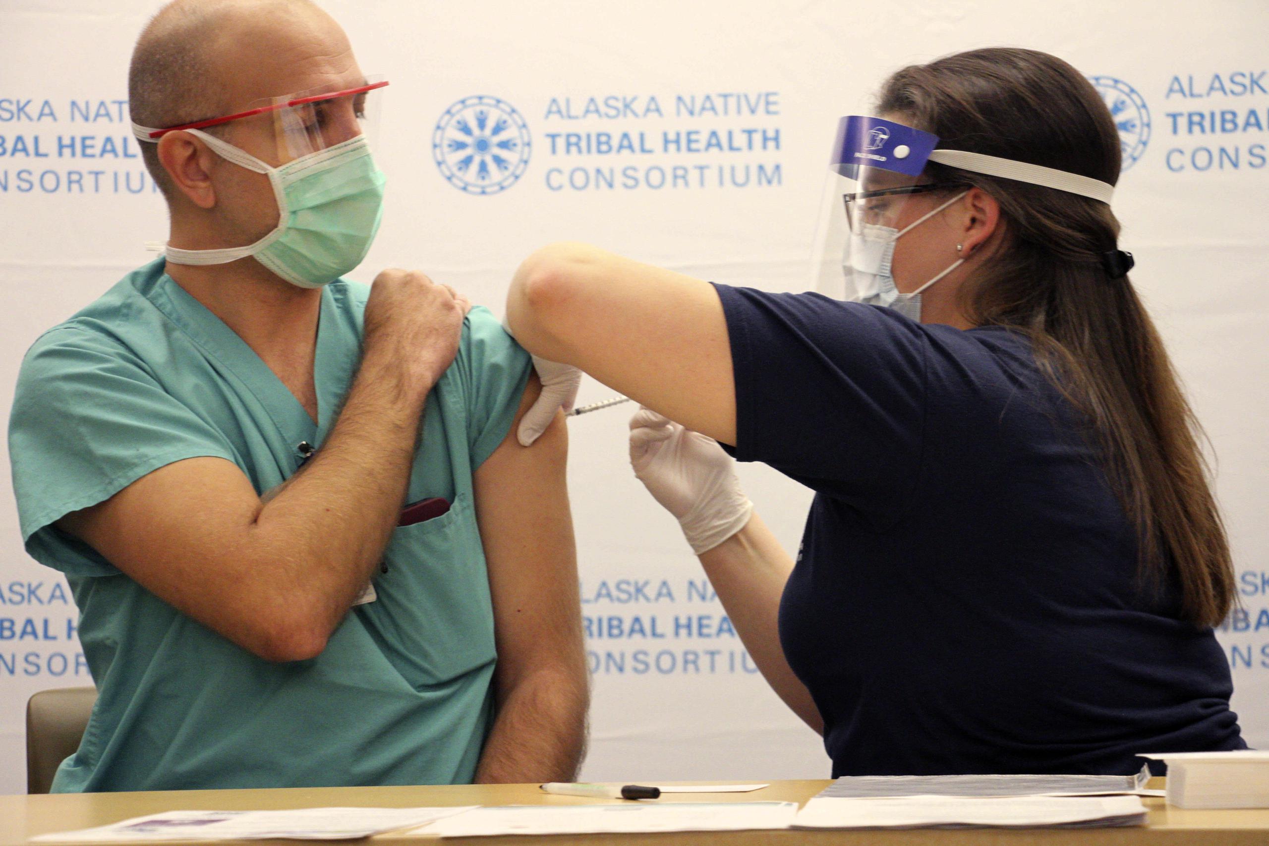 El doctor David Zielke, un neumólogo especializado en terapia intensiva, recibe una de las dos dosis de la vacuna contra el COVID-19 de manos de la enfermera Emily Schubert, en el Alaska Native Medical Center, en Anchorage, Alaska.