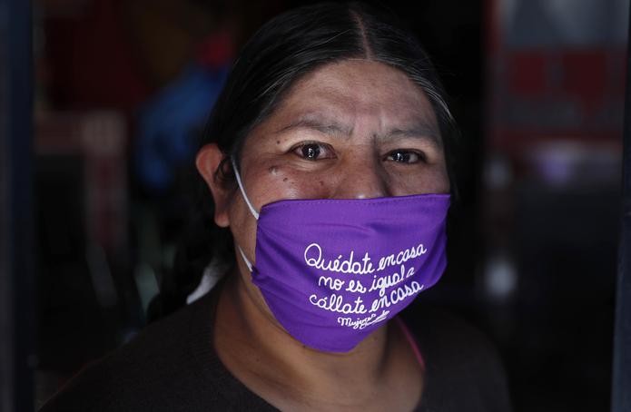 Emiliana Quispe posa para un retrato con una máscara facial que dice "Quédate en casa no es igual a cállate en casa'", en la sede de la organización feminista Mujeres Creando en La Paz, Bolivia.