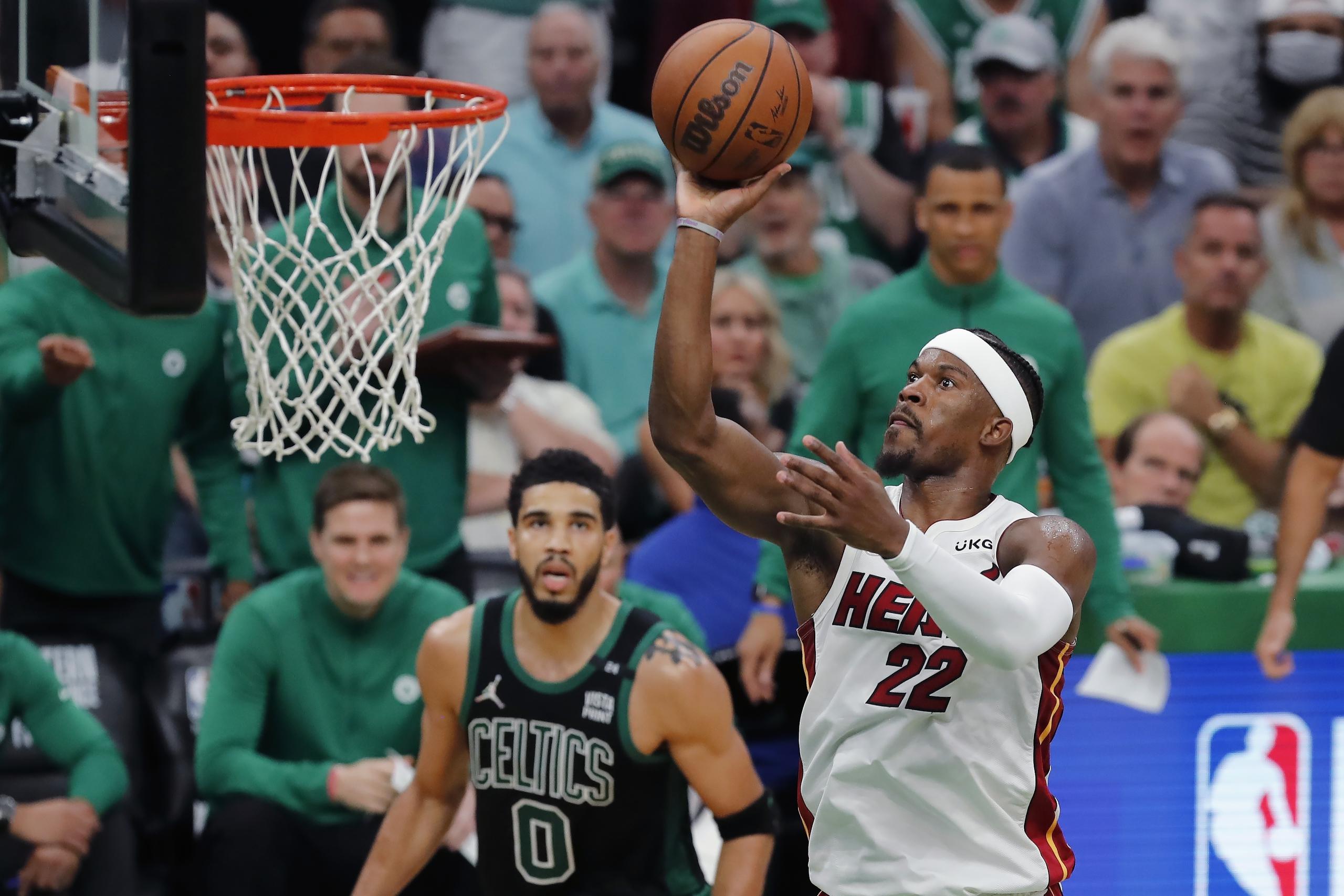 Jimmy Butler, del Heat de Miami, realiza un disparo mientras Jayson Tatum (0) , de los Celtics, le observa.