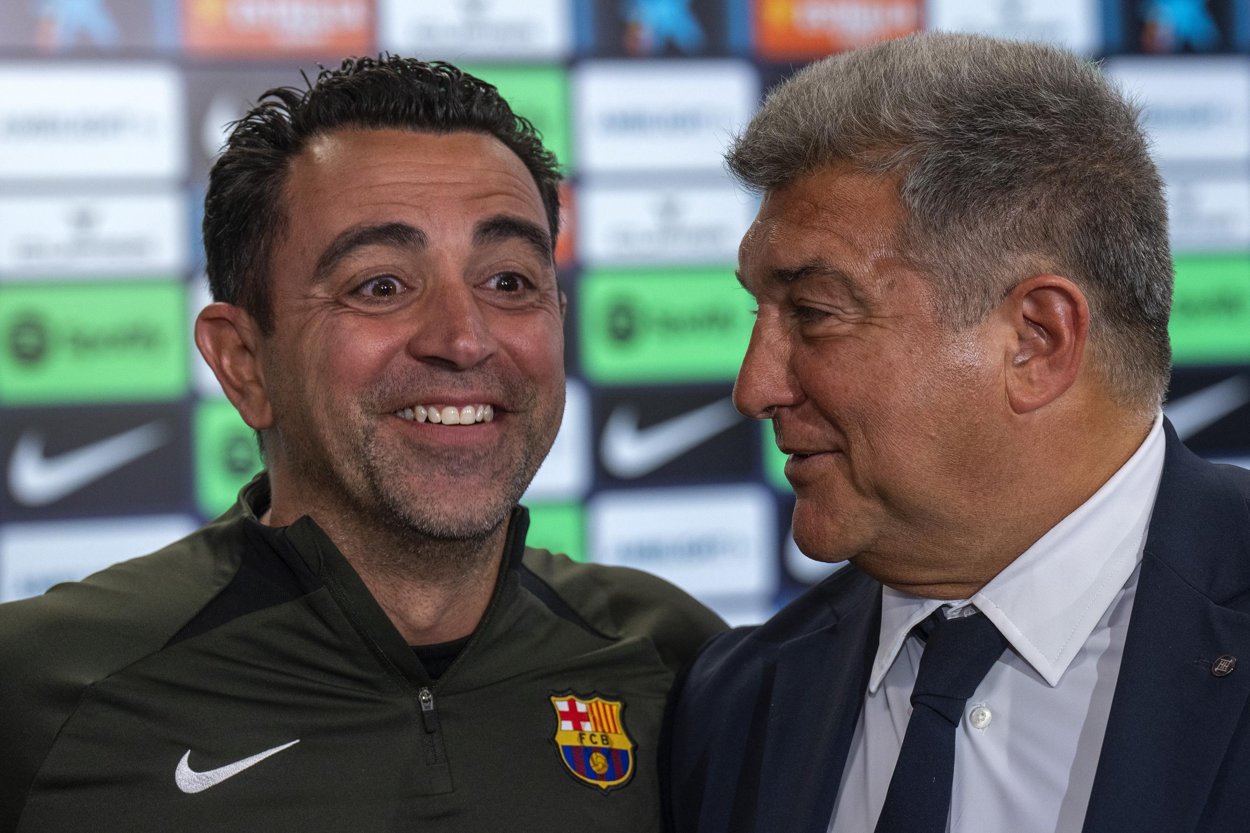 El técnico del Barcelona Xavi Hernández sonríe al lado del presidente Joan Laporta durante una rueda de prensa, el jueves 25 de abril de 2024.