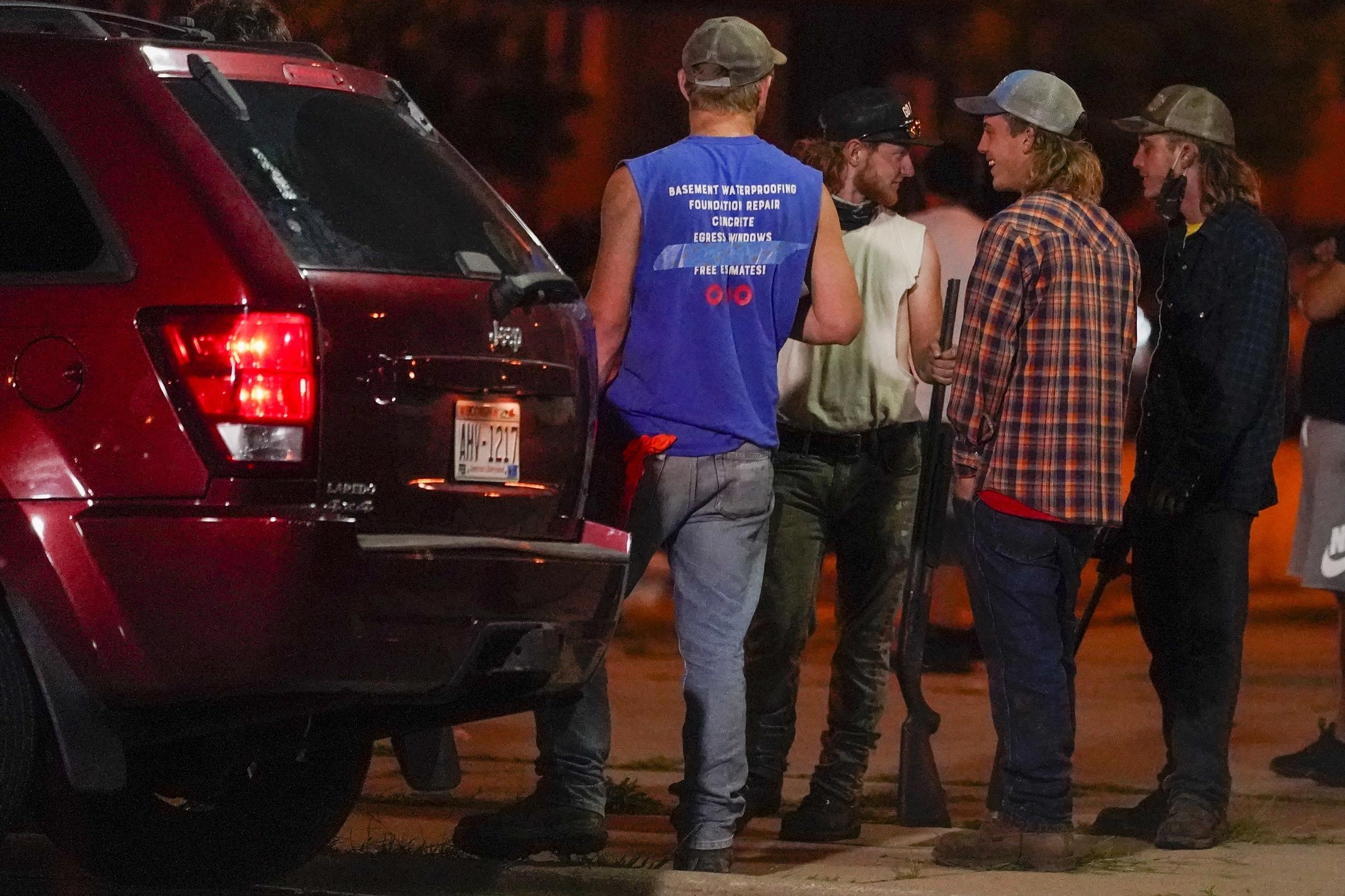 Individuos armados observan una manifestación de protesta por la muerte de Jacob Blake a manos de la policía en Kenosha, Wisconsin.