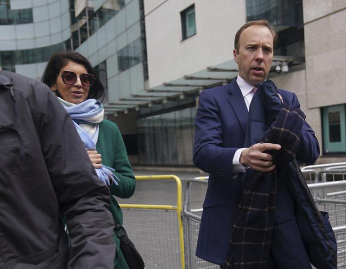 El secretario de salud británico Matt Hancock, a la derecha, camina con su asistente Gina Coladangelo, afuera de la BBC Broadcasting House en Londres después de su aparición en el programa de actualidad de BBC1, The Andrew Marr Show.