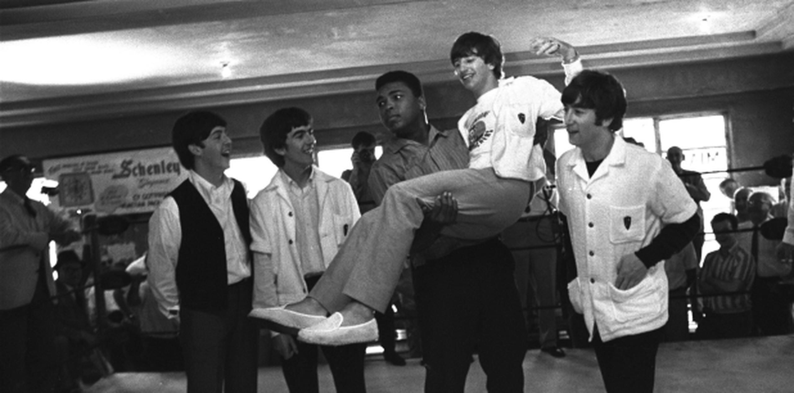 Clay aparece noqueando a los Beatles como dominós, y parado con los músicos tirados en la lona. (Prensa Asociada)