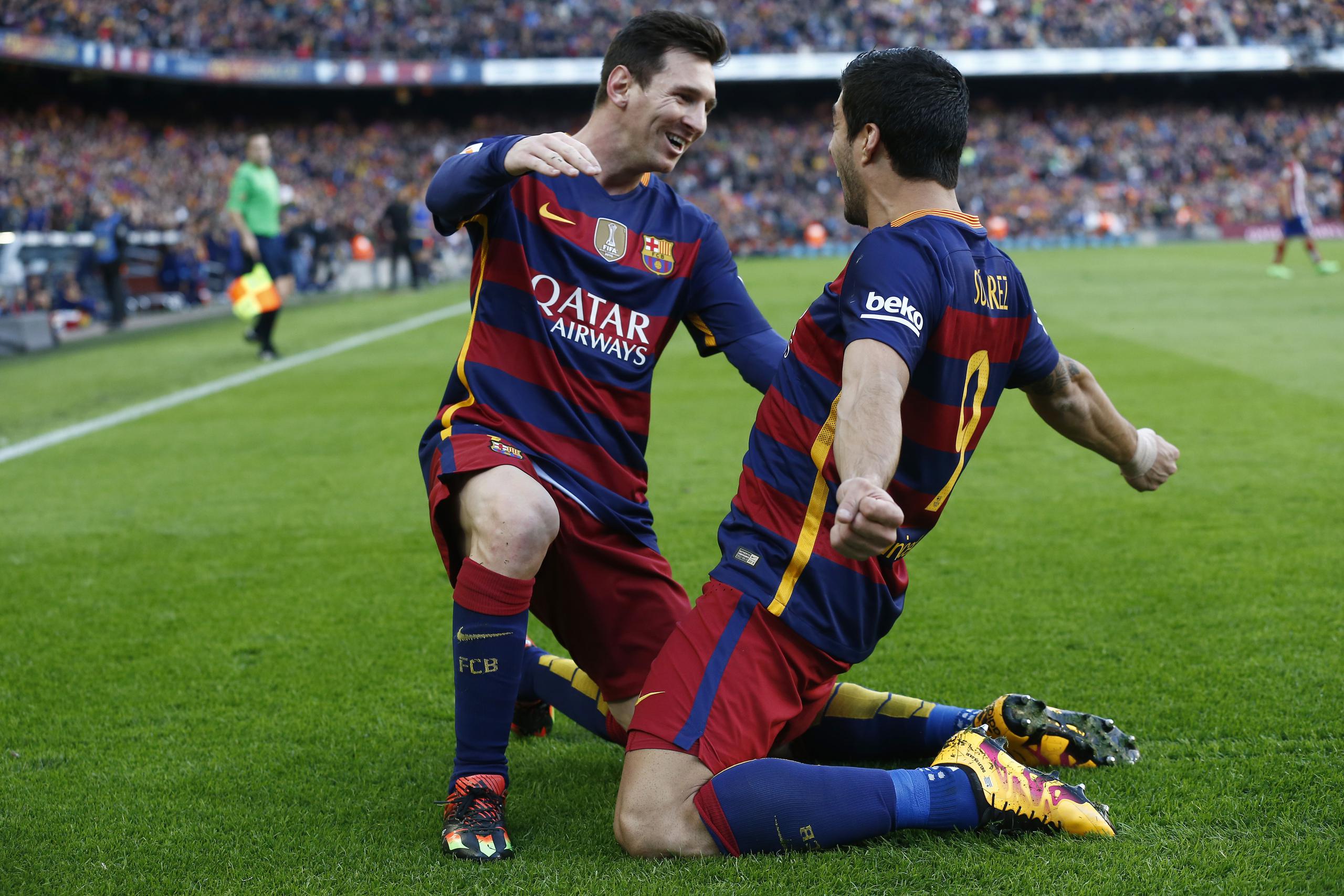 Luis Suárez, derecha, festeja con su compañero Lionel Messi tras anotar uno de los dos goles del Barcelona en el partido. (AP)