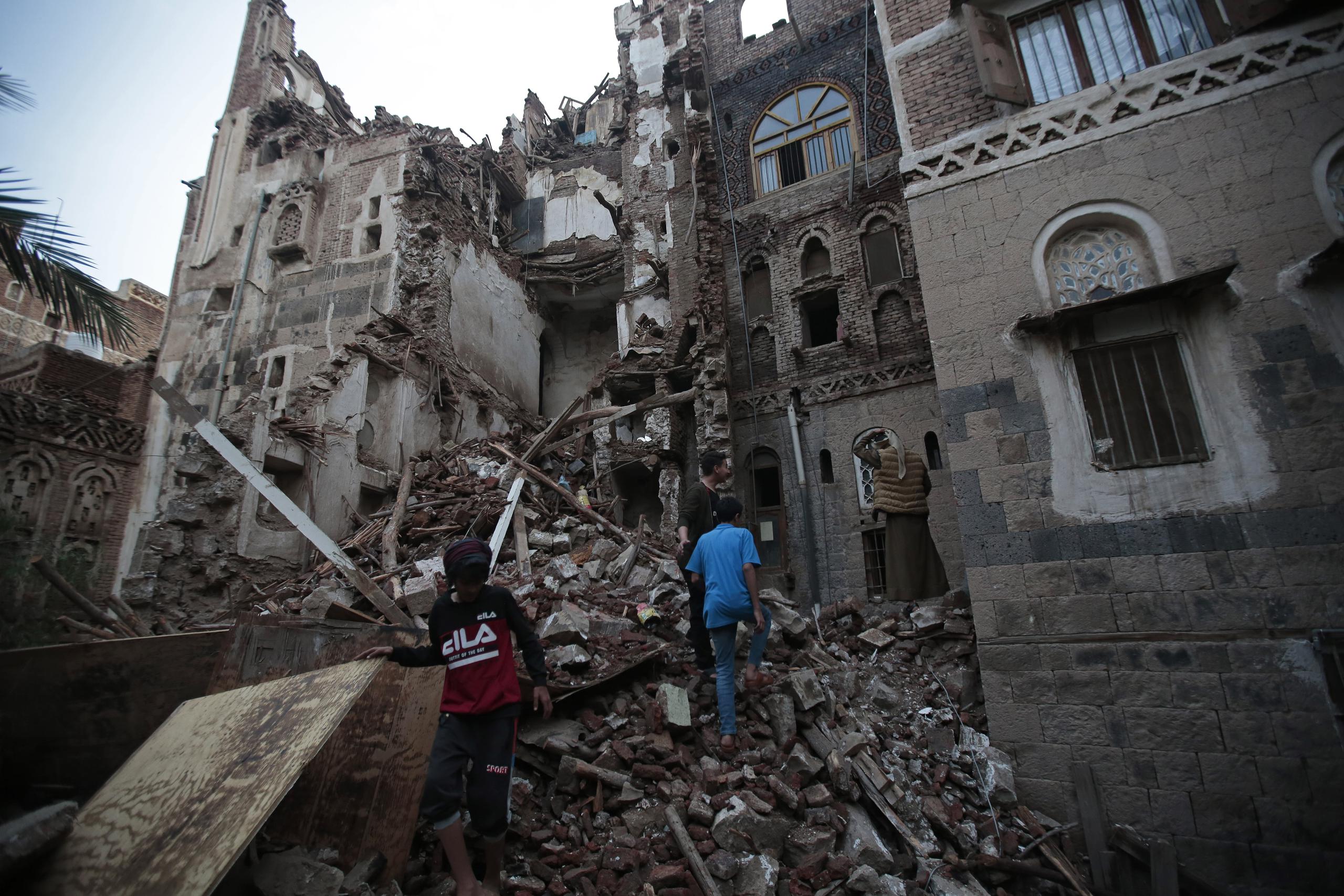 Yemeníes observan las ruinas de un edificio que se desplomó, el miércoles 10 de agosto de 2022, en la Ciudad Vieja de Saná, Yemen. (AP Foto/Hani Mohammed)