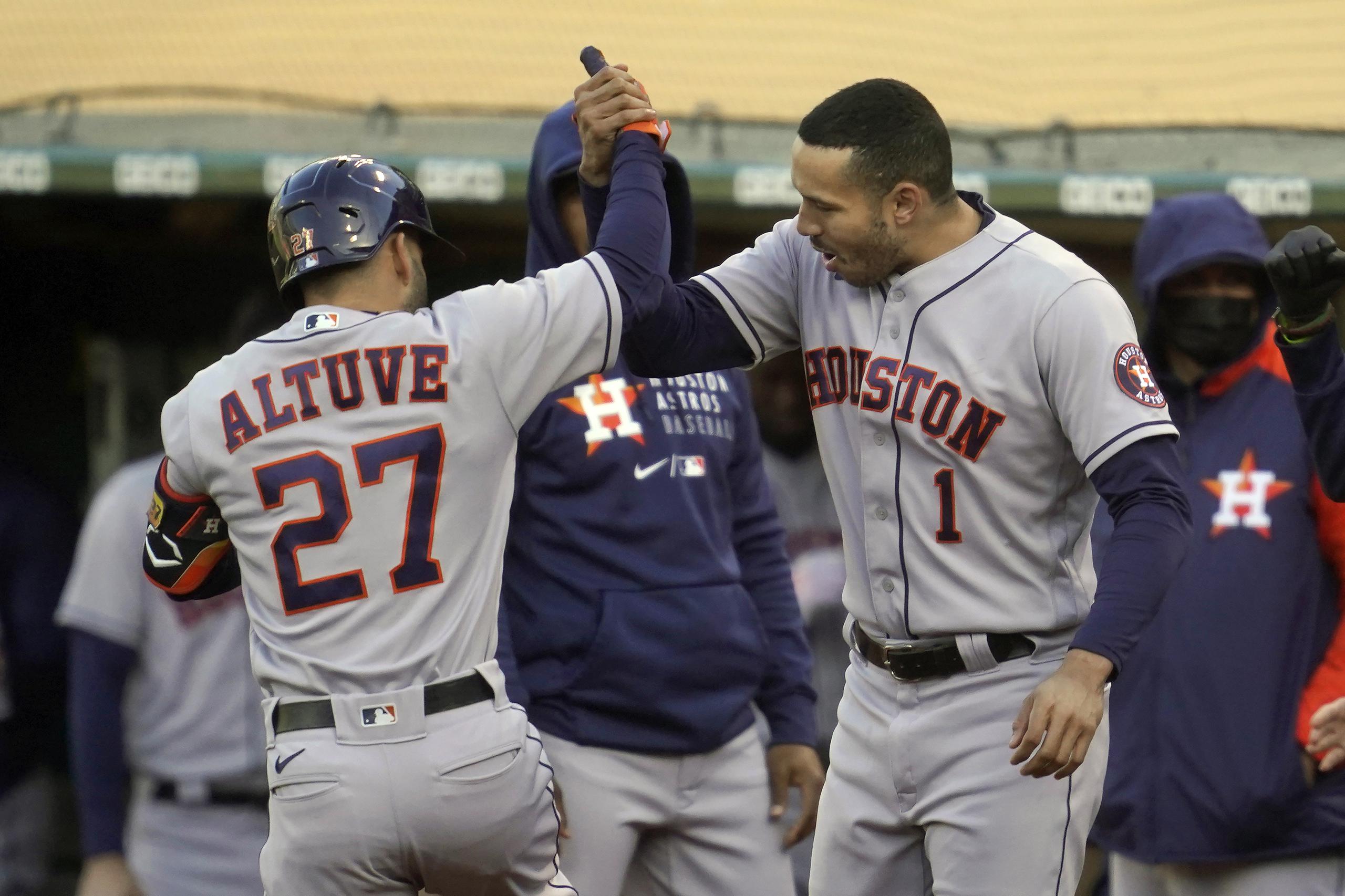 José Altuve, de los Astros de Houston, es felicitado por Carlos Correa (1) tras pegar un jonrón contra los Atlethics de Oakland en el primer inning del juego de anoche.