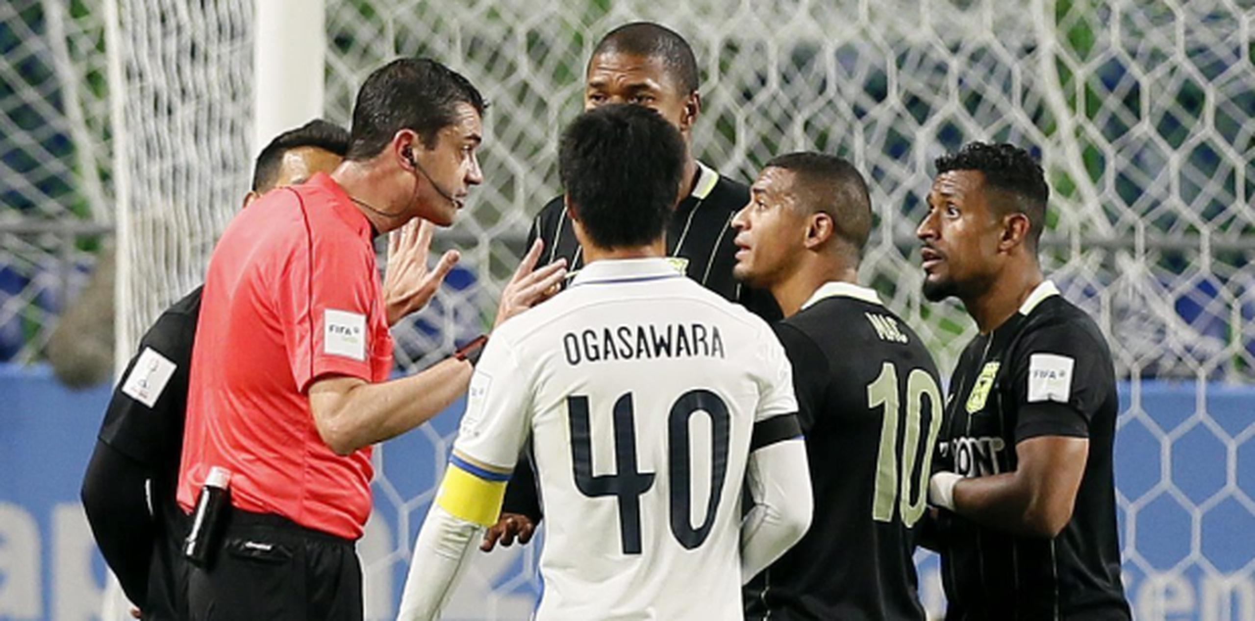Jugadores del Atlético Nacional colombiano discuten con el árbitro Viktor Kassai luego que pitara un penal a favor del Kashima Antlers tras revisar una jugada en un monitor. (EFE/Kimimasa Mayama)