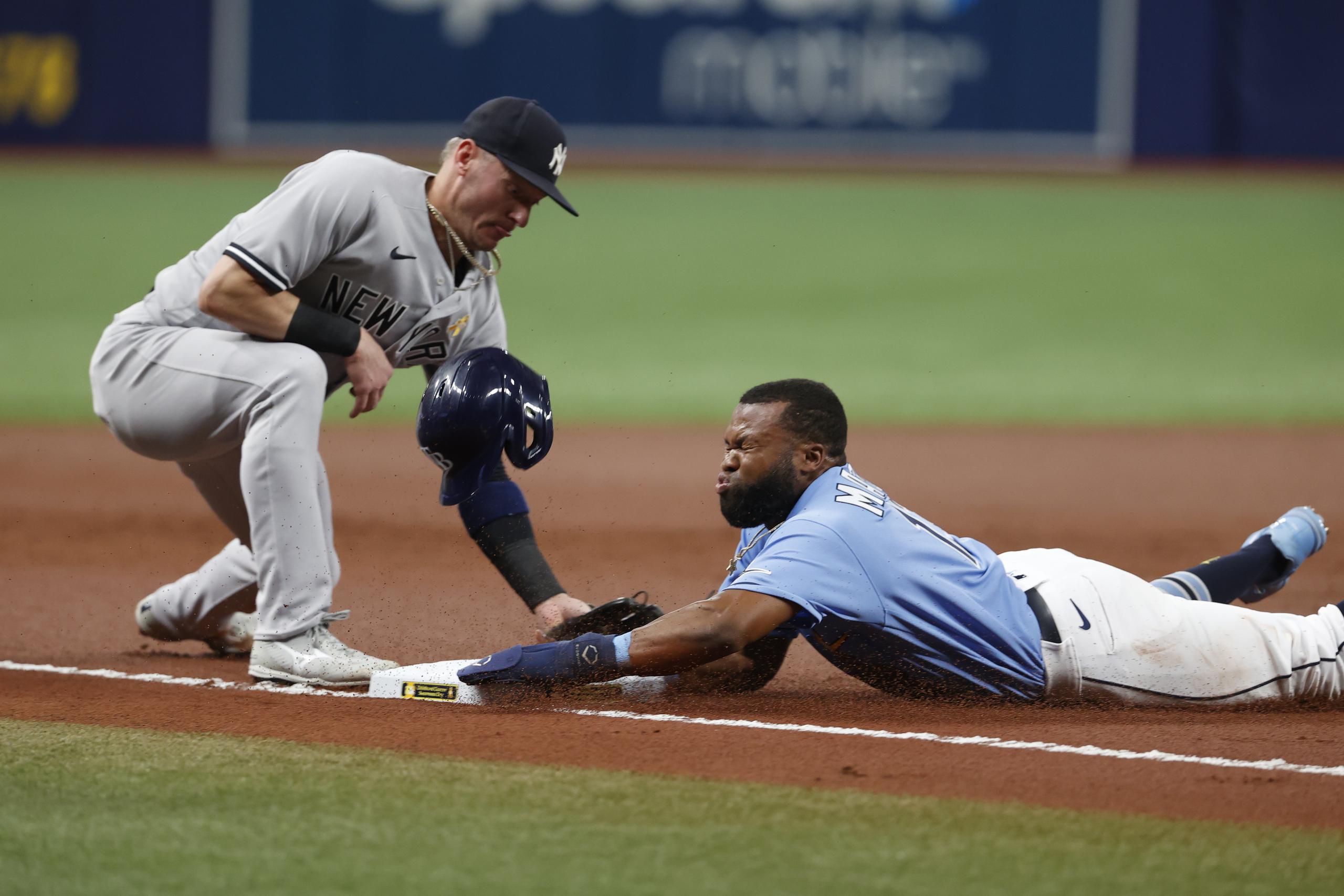 El corredor de los Rays de Tampa Bay, Manuel Margot, se desliza a salvo en la antesala pese a la gestión de Josh Donaldson, de los Yankees, durante el desafío del viernes.
