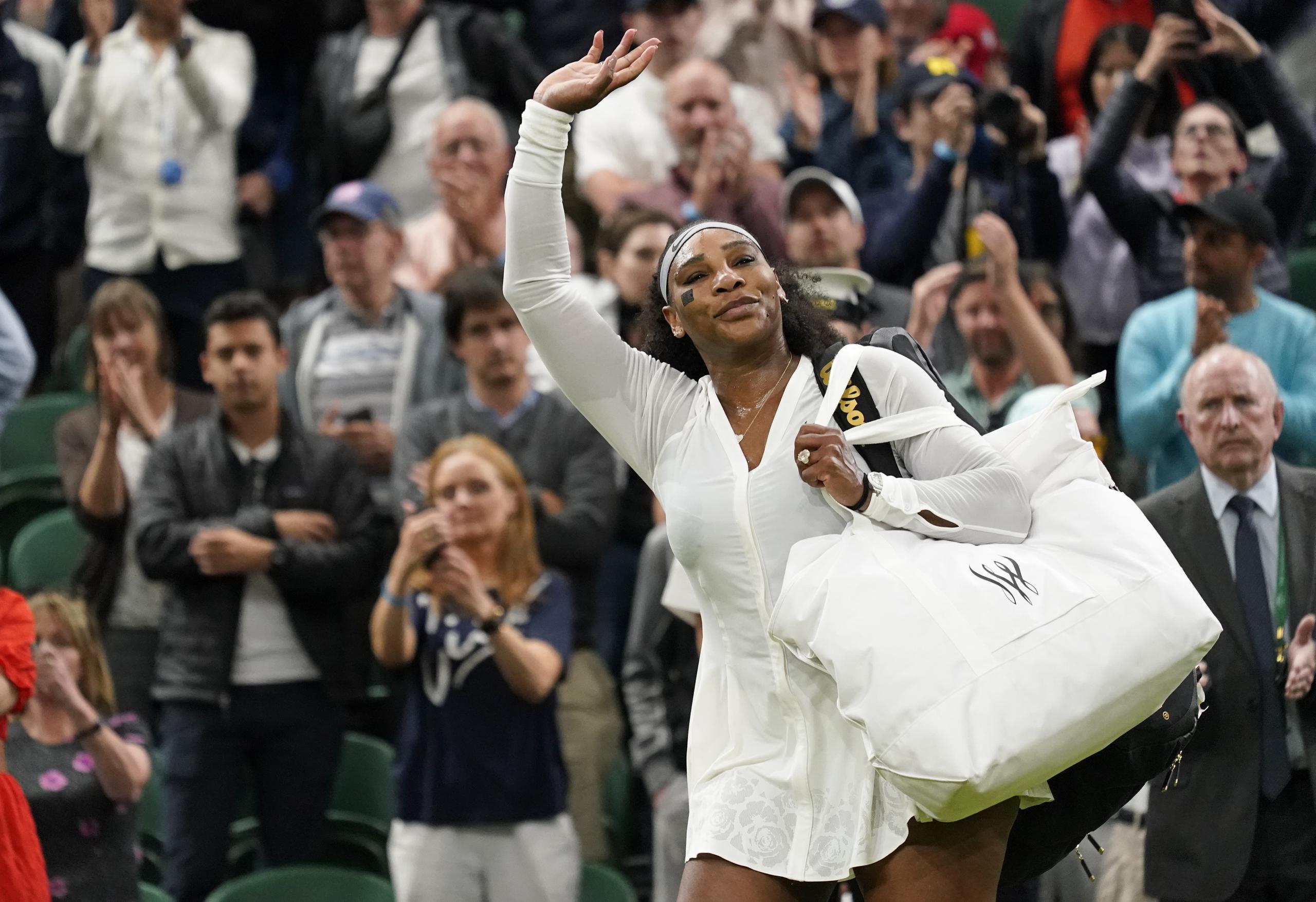 La estadounidense Serena Williams saluda a la afición al salir de la cancha tras su derrota en la primera ronda de Wimbledon ante la francesa Harmony Tan el martes 28 de junio del 2022. (AP Foto/Alberto Pezzali)
