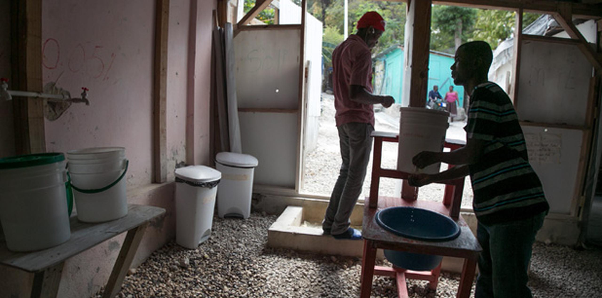 Personal se lava las manos antes de ingresar a una sede de Médicos sin Fronteras para el tratamiento del cólera. (EFE)