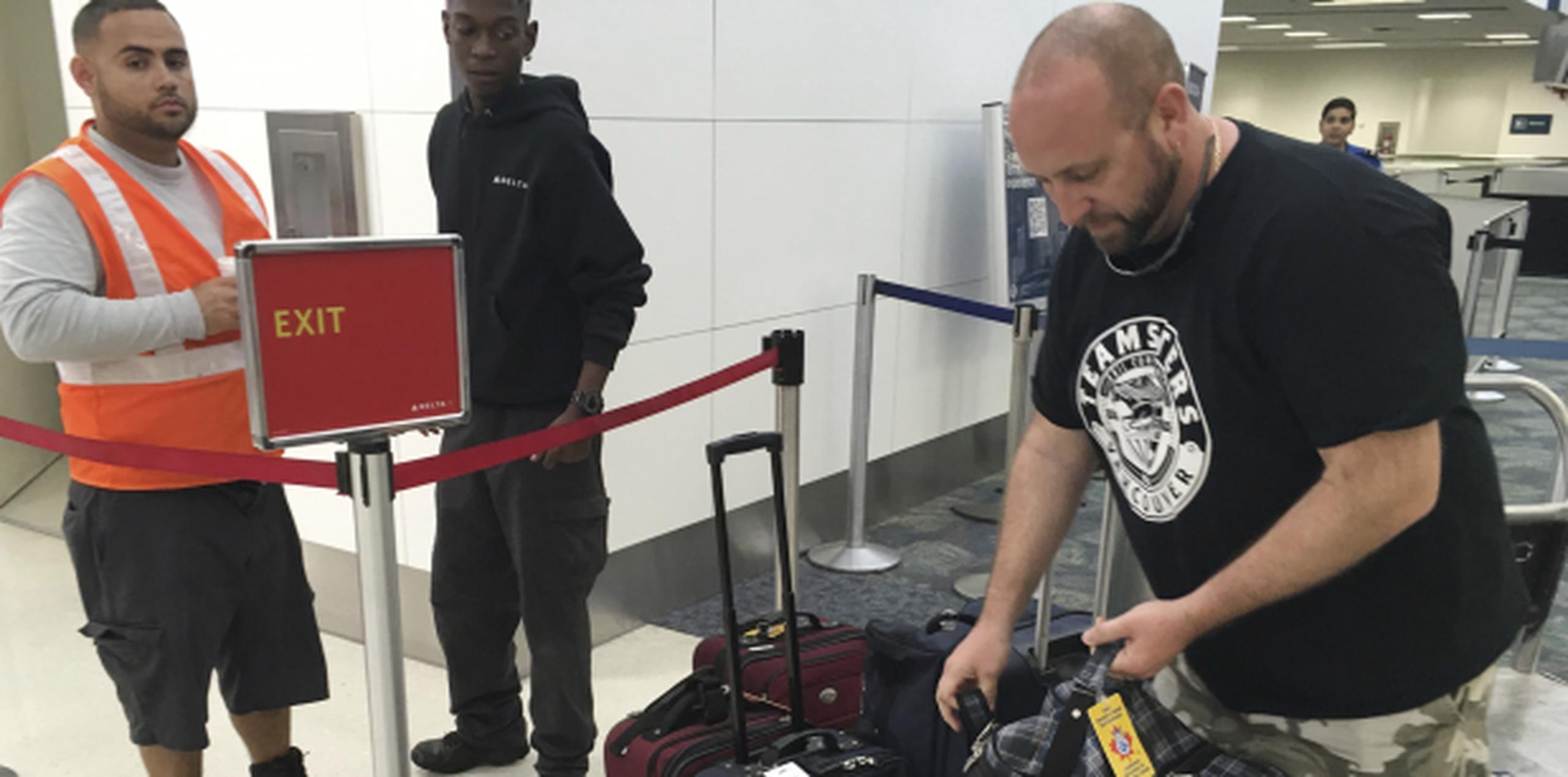 Dan Kovac busca sus maletas en el aeropuerto de Ft. Lauderdale. (AP)