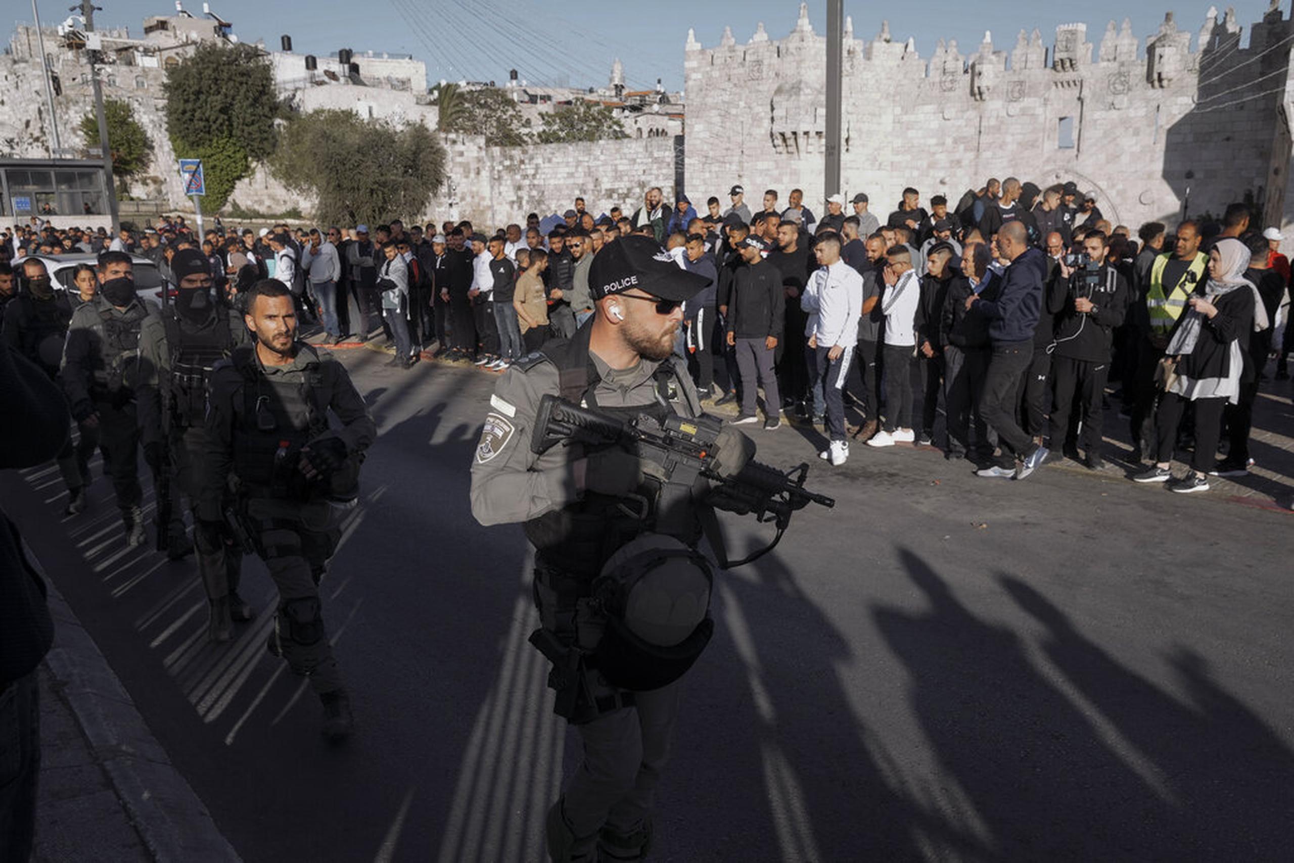 Palestinos observan a las fuerzas de seguridad israelíes el 20 de abril de 2022, en las afueras de la Ciudad Vieja de Jerusalén.