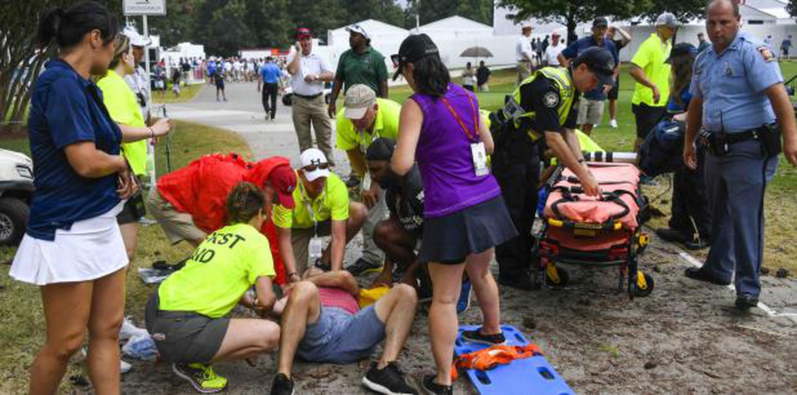 Espectadores reciben atención médica tras la caída de un rayo durante la tercera ronda del Campeonato del Tour de golf, el sábado en Atlanta. (AP /John Amis)