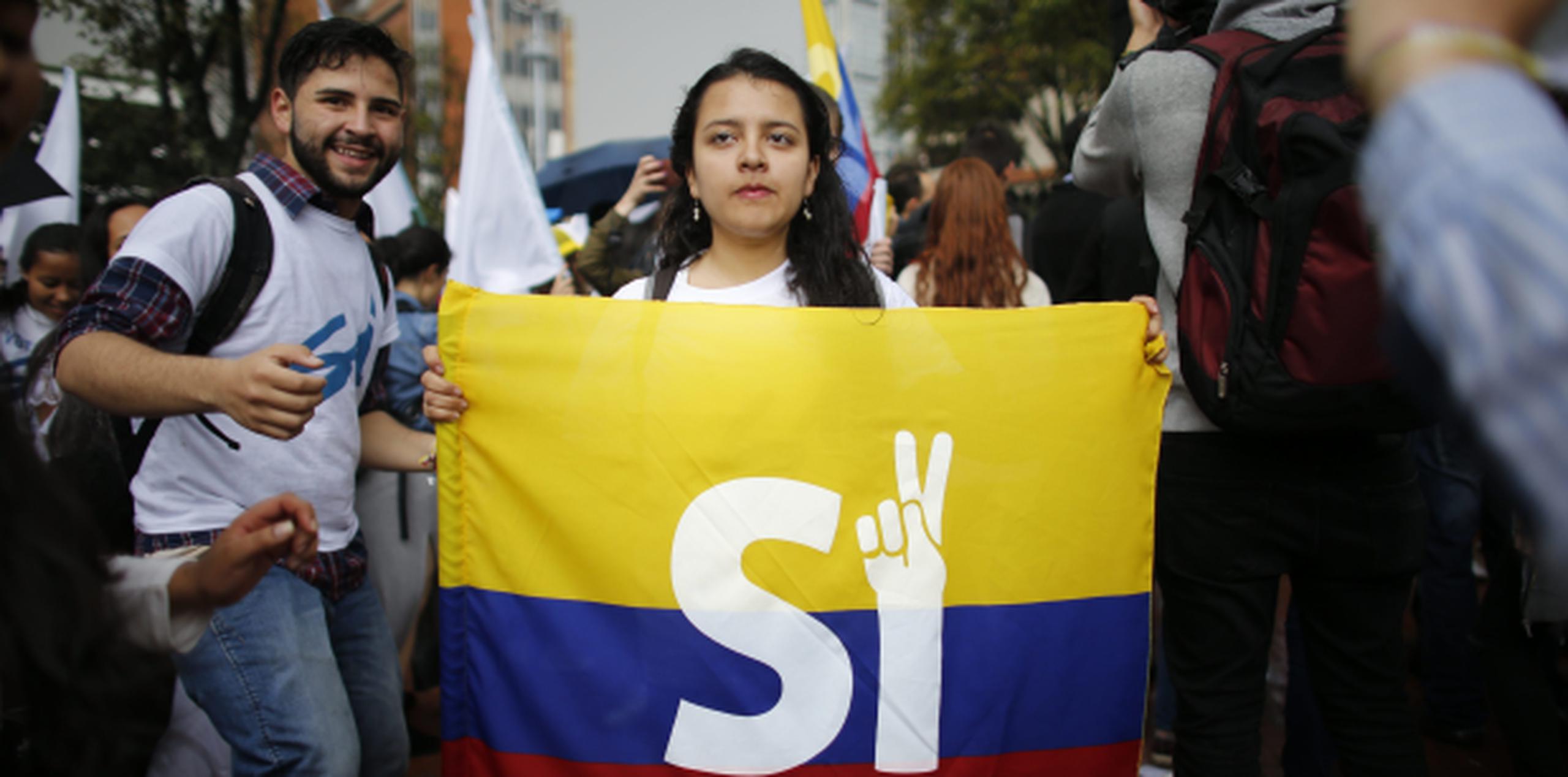 Una mujer con una bandera de Colombia y la palabra Sí en una marcha a favor de que se avale el proceso de paz con las FARC. (AP)