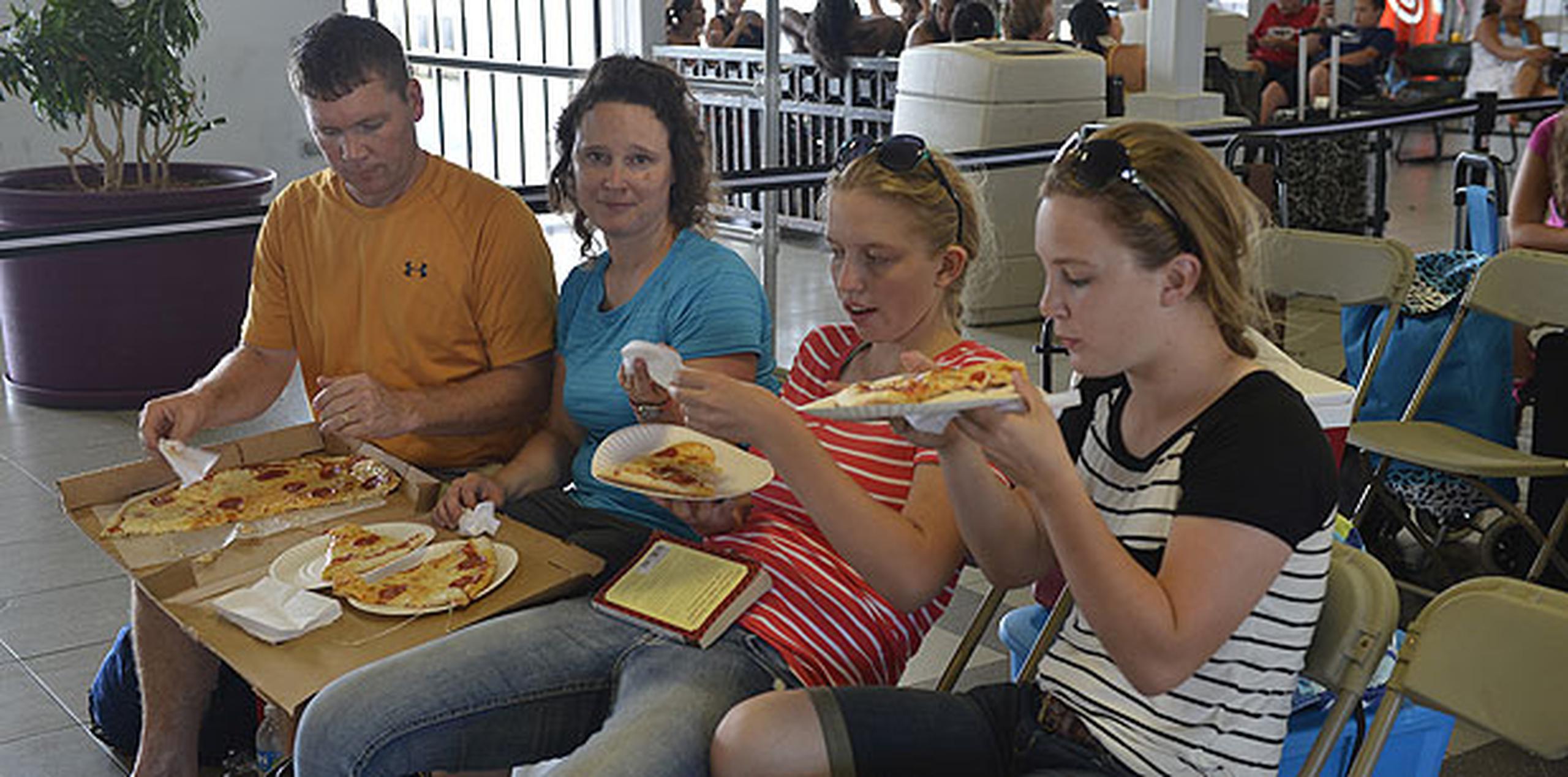 Una familia de turistas comía pizza mientras esperaba la lancha. (ismael.fernandez@gfrmedia.com)