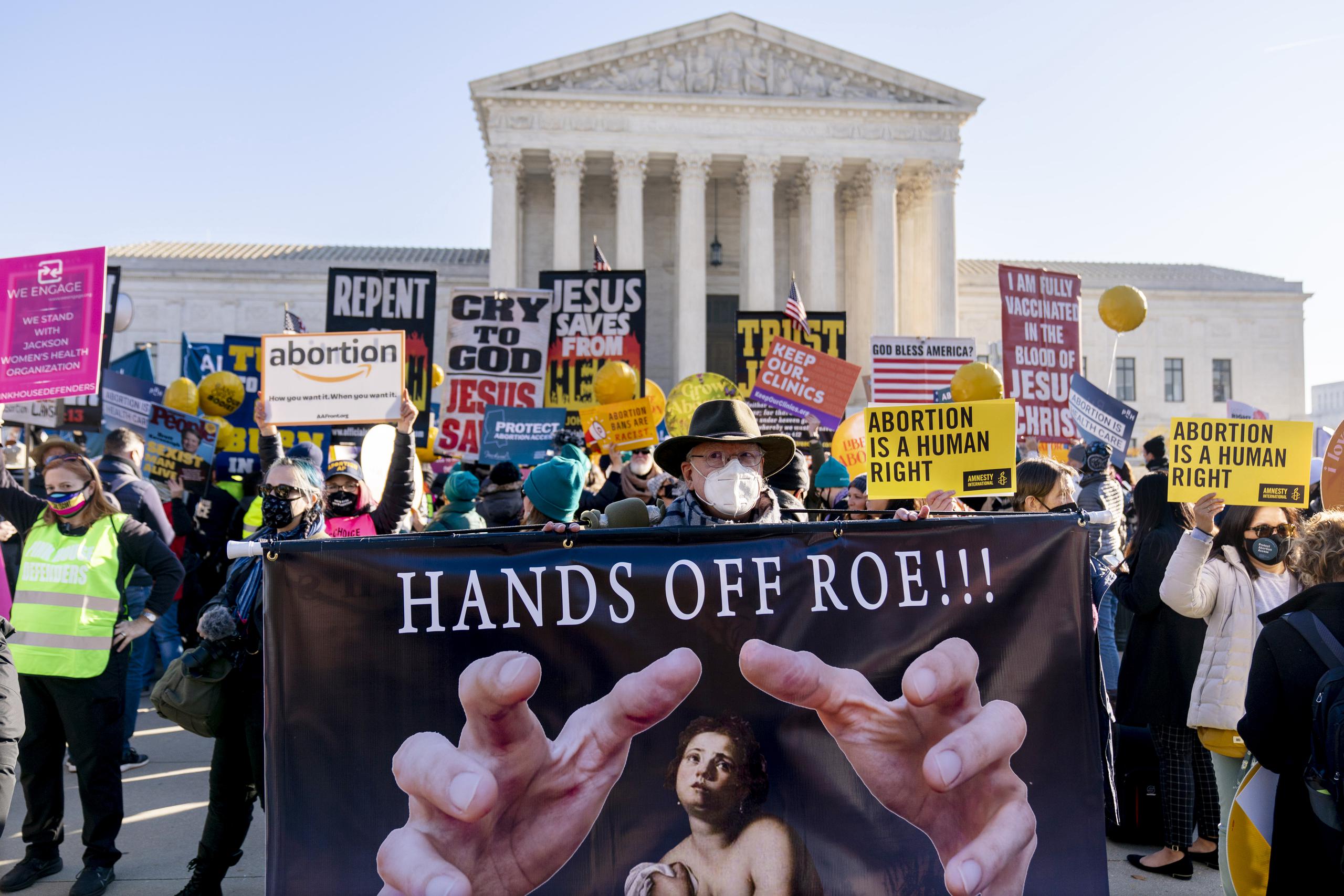 Stephen Parlato de Boulder, Colorado, sostiene un letrero que dice "Hands Off Roe!!!" ("¡No toques a Roe!") durante una manifestación de personas a favor y en contra del aborto frente a la Corte Suprema de Estados Unidos el 1 de diciembre de 2021 en Washington. (AP Foto/Andrew Harnik, Archivo)