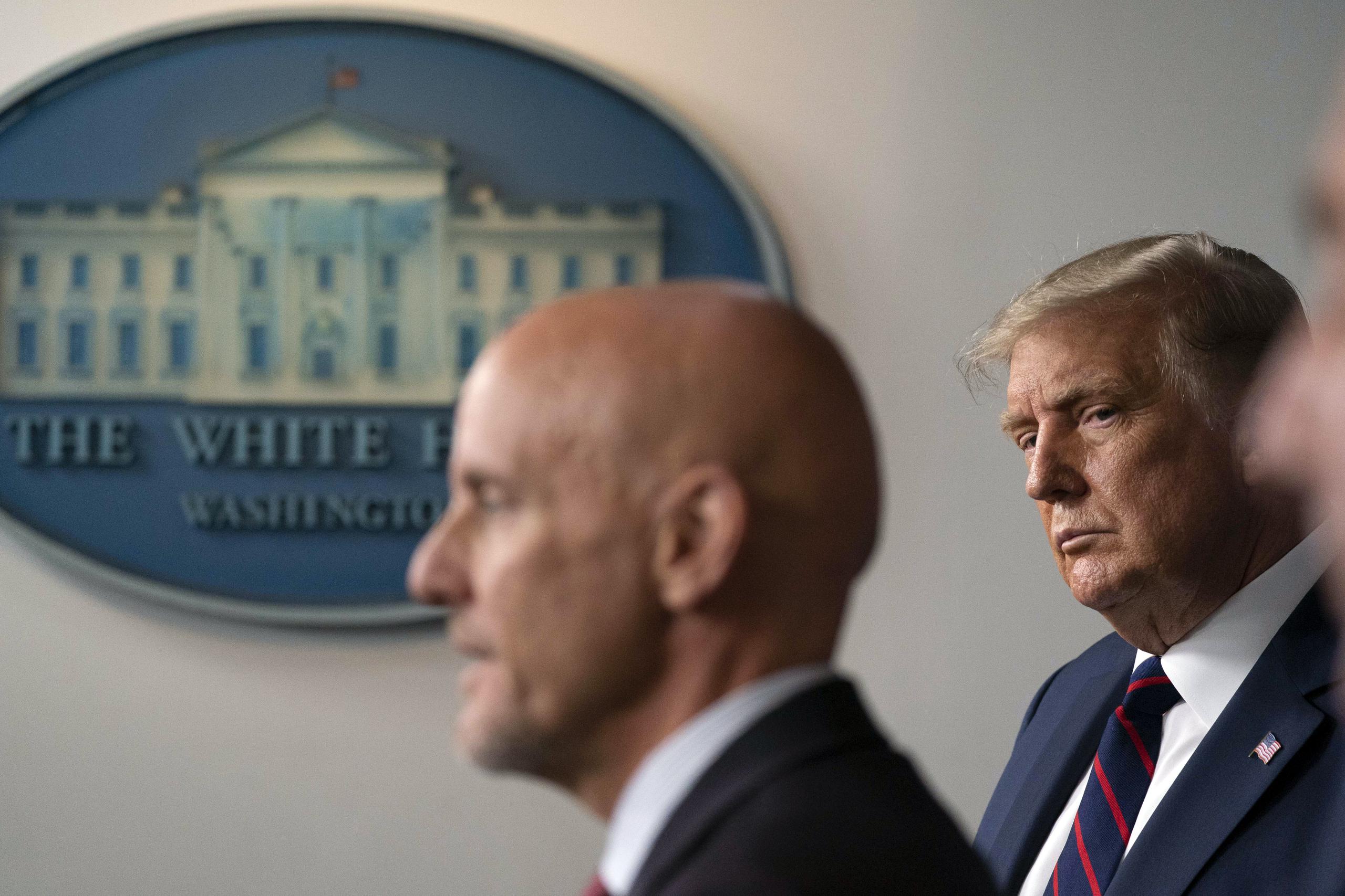 El presidente Donald Trump observa al jefe de la FDA, Stephen Hahn, durante una conferencia de prensa en la Casa Blanca el pasado agosto.